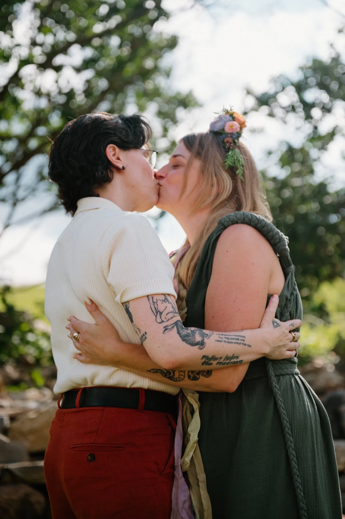 Queer couple sharing their first kiss during their wedding ceremony at a farm near Orangeville, Ontario