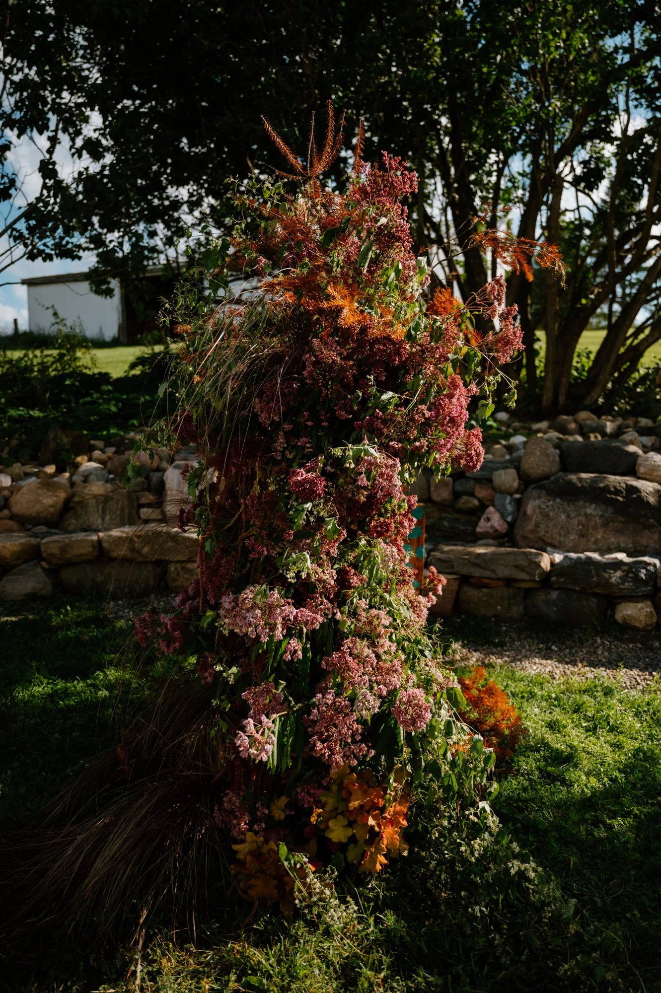 Detail of an outdoor floral installation by Smells Like Flowers at an LGBTQ+ farm wedding near Orangeville, Ontario