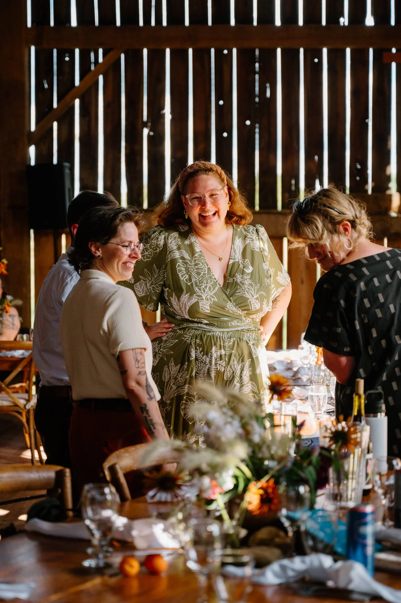 Candid documentary photo of guests laughing and mingling during an LGBTQ+ barn wedding reception in Ontario