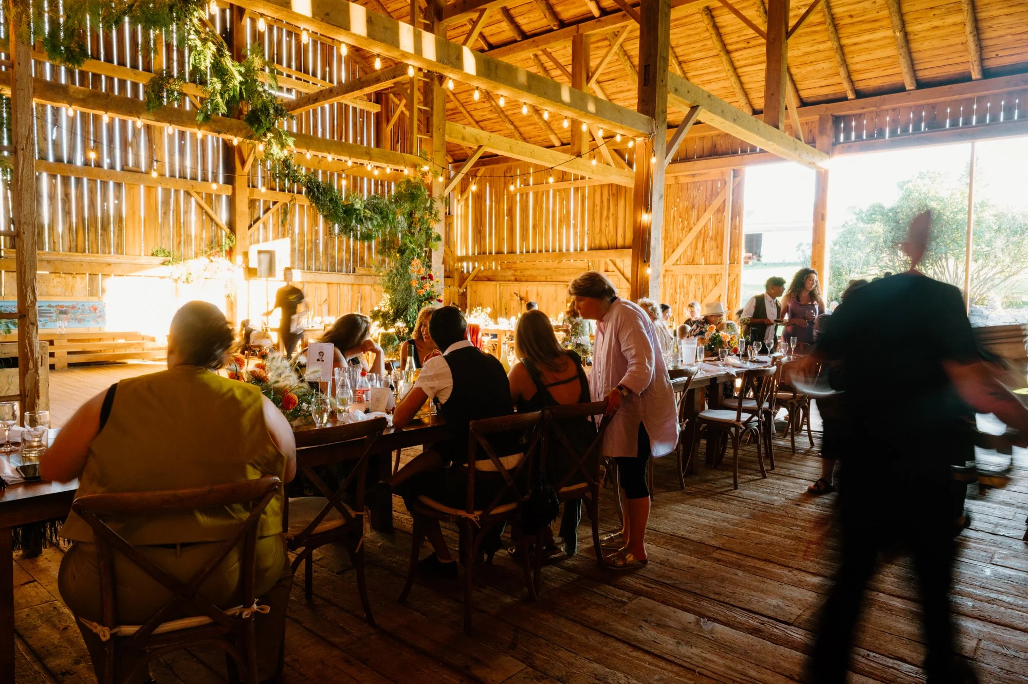 Wide room photo of guests during an intimate farm wedding reception near Orangeville, Ontario