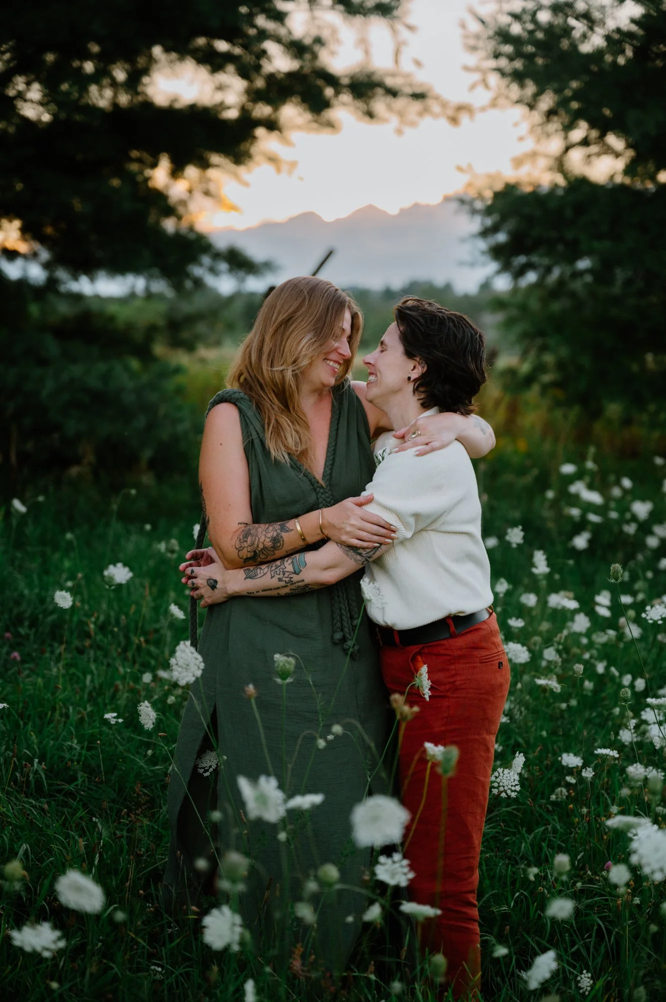 Portrait of a queer couple standing together in a field at sunset during their farm wedding near Orangeville, Ontario