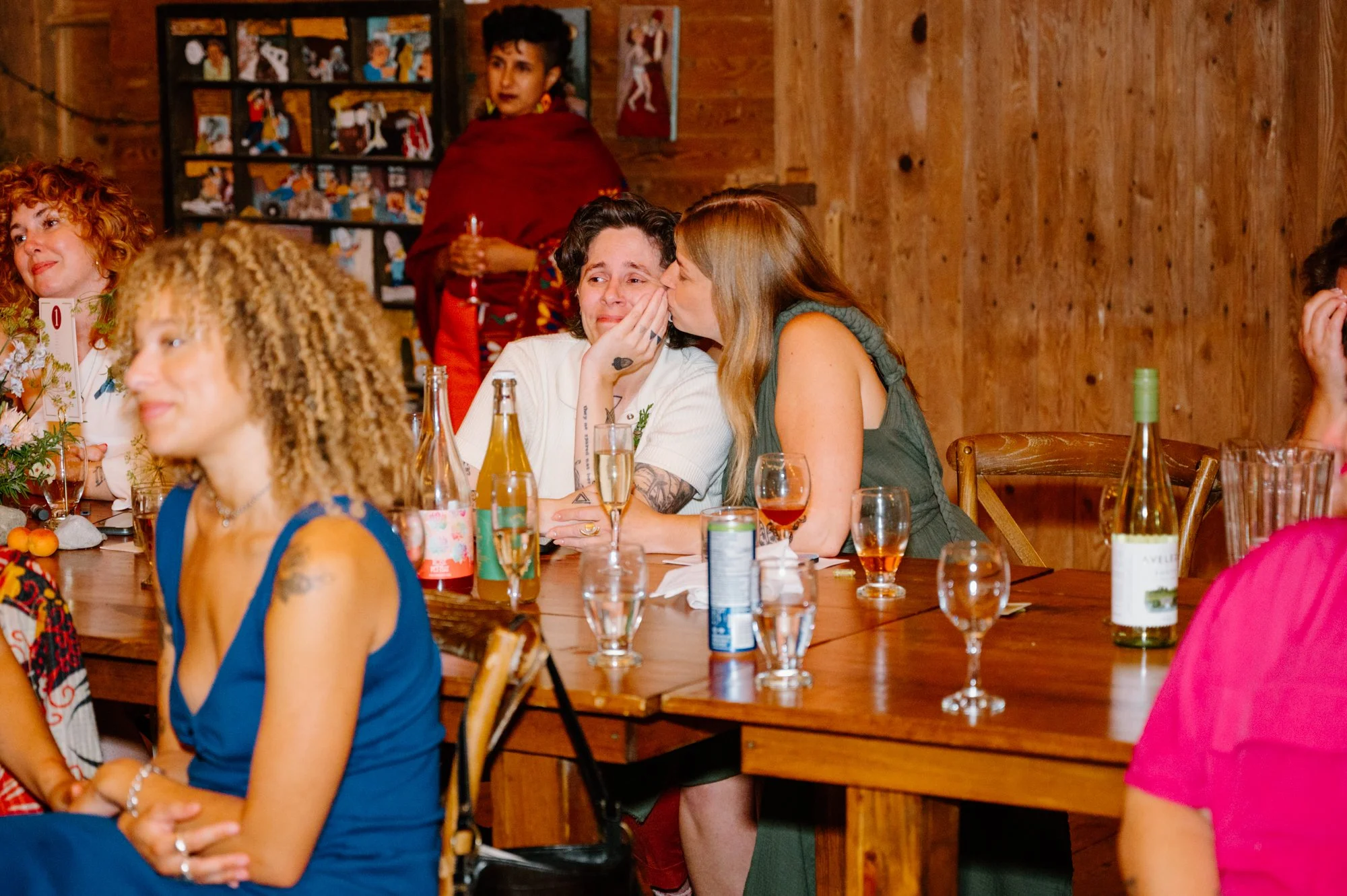 Candid photo of a queer couple sharing an emotional moment during their farm wedding reception near Orangeville