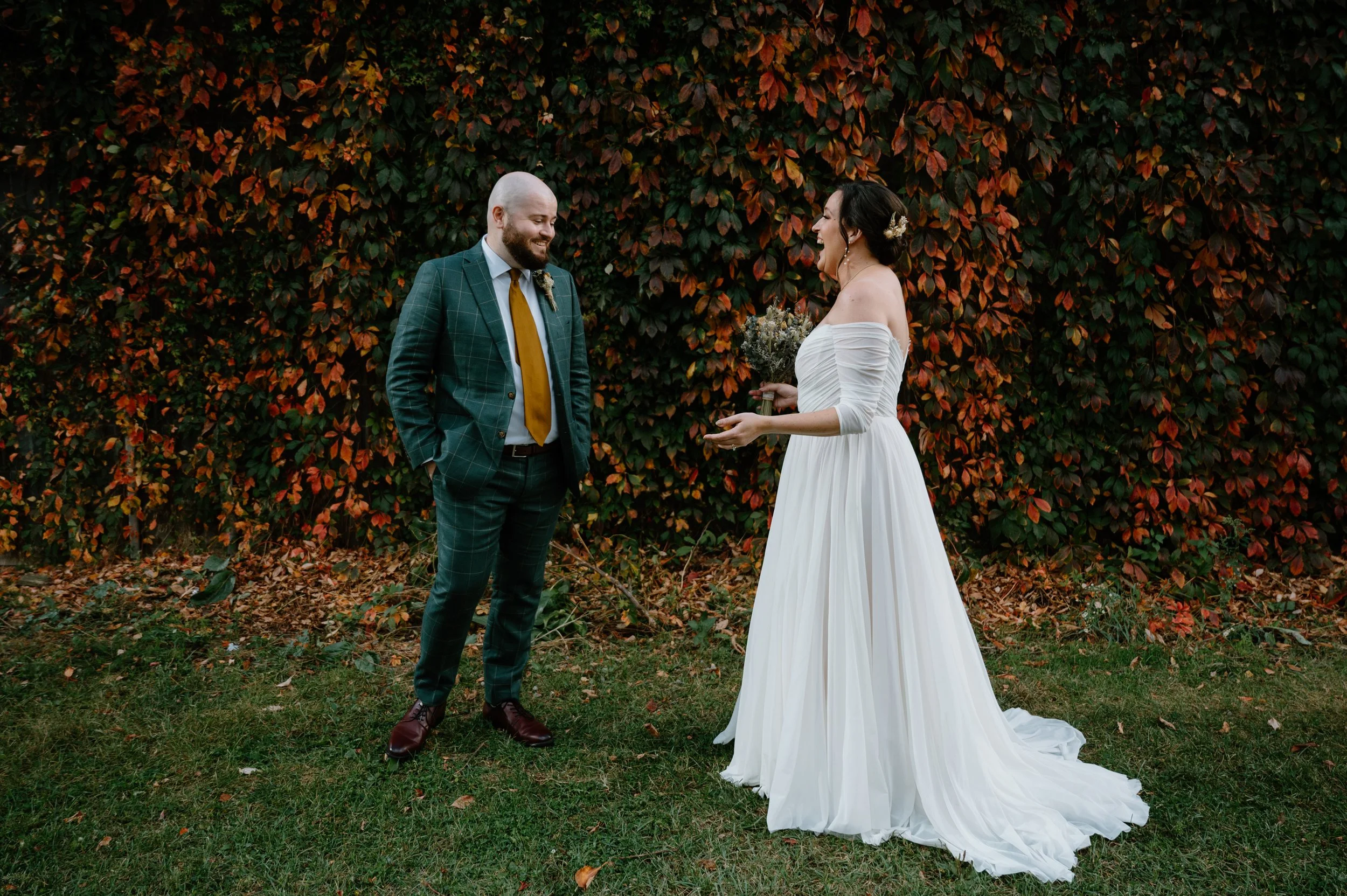 A tender first look between a bride and groom at Steam Whistle Brewery with fall foliage in the background during a Toronto wedding