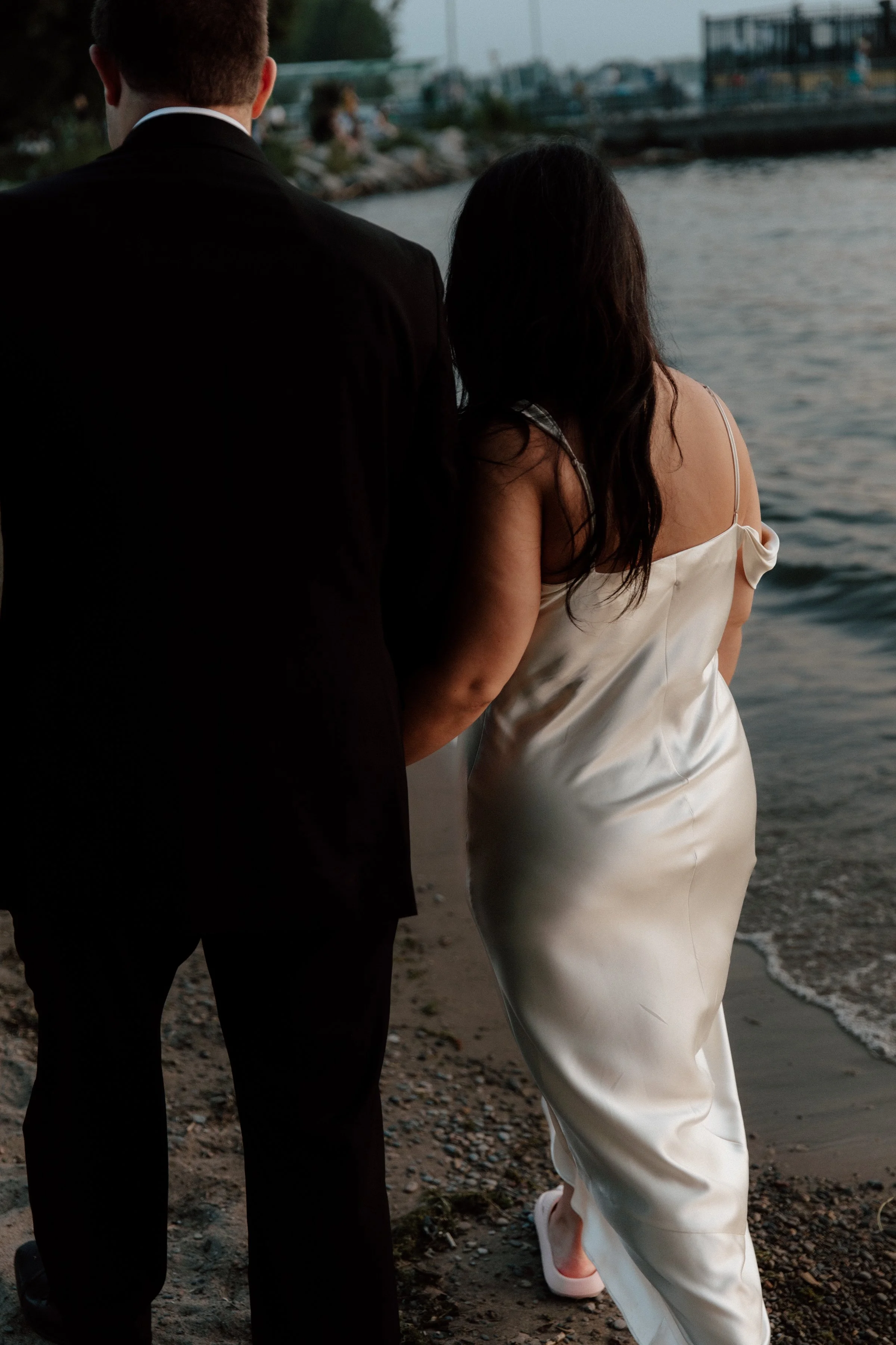 Editorial portrait of a couple walking along the beach at sunset on the Toronto Islands