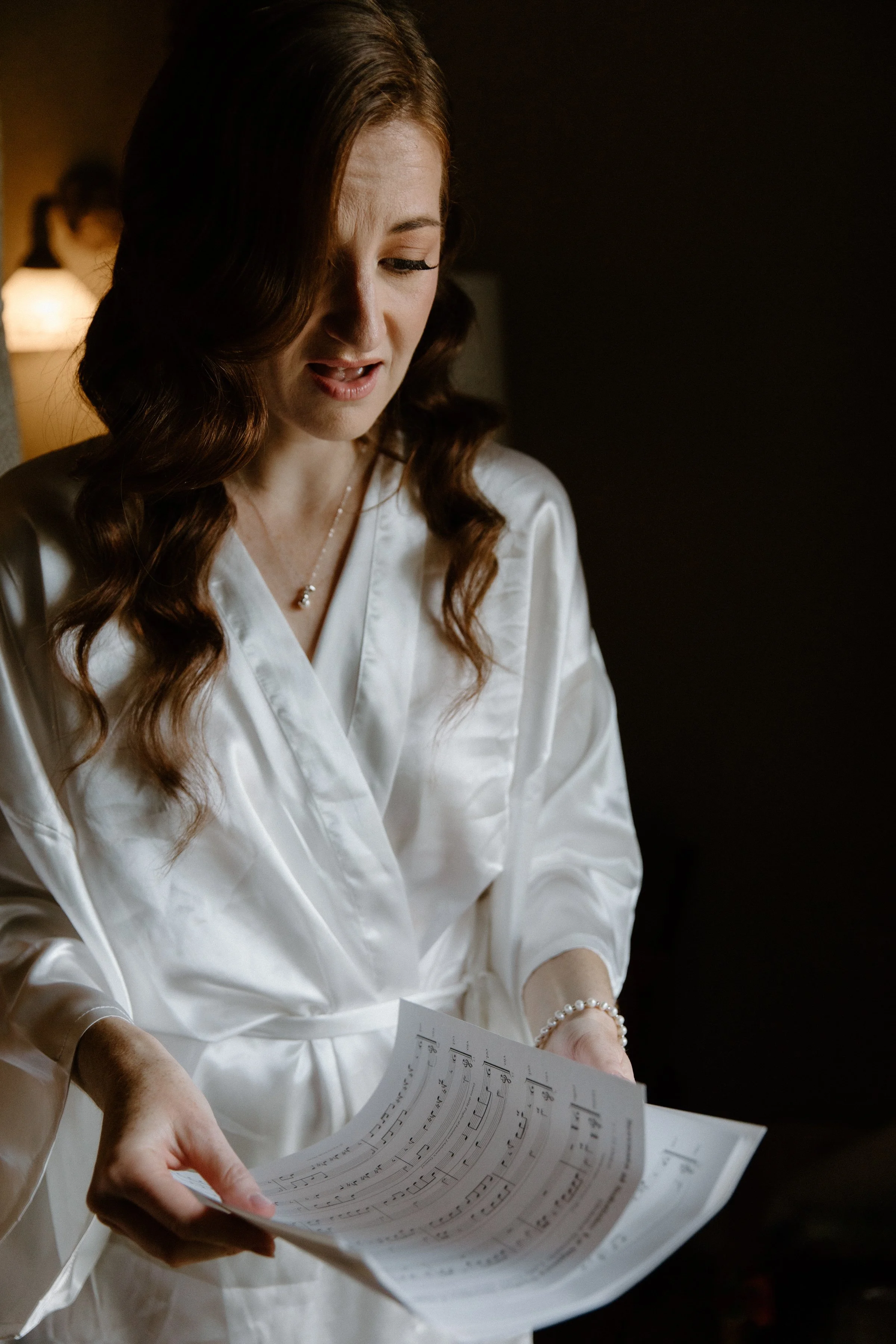 Candid photo of a bride reading a surprise piece of sheet music from her groom on their Toronto wedding day