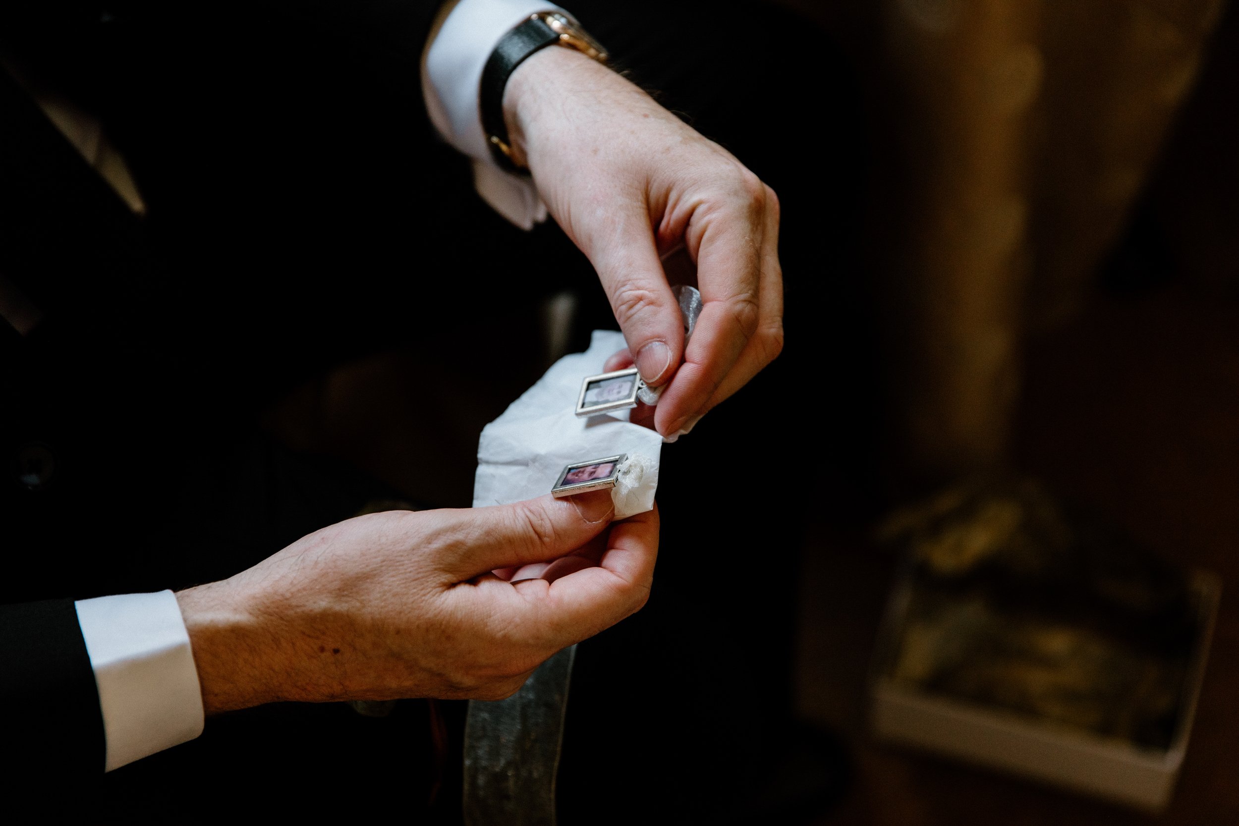 Candid photo of a groom holding a sentimental gift from his brother on his Toronto wedding day