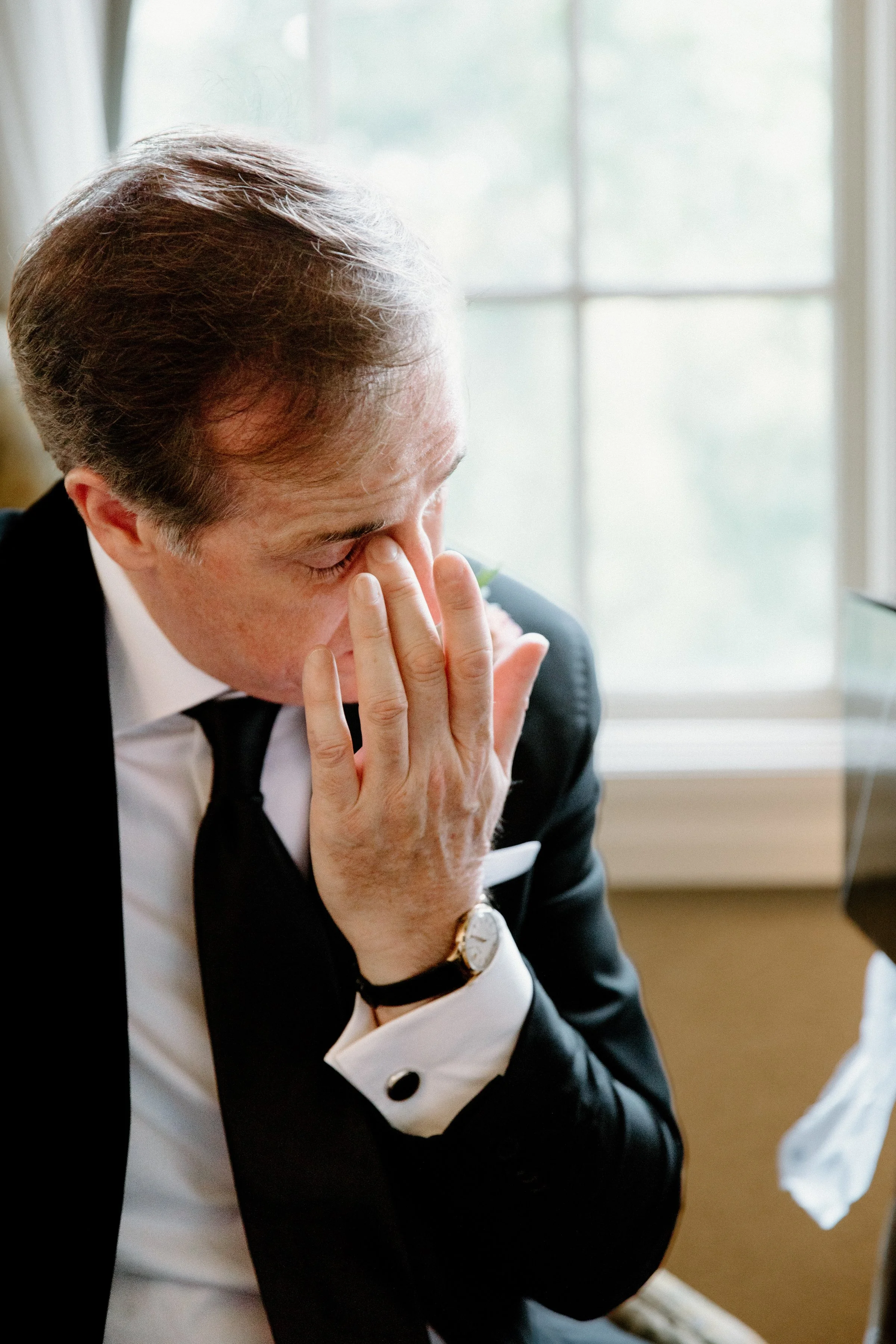 Candid colour photo of a groom getting emotional while reading a card from his bride on their Toronto wedding day