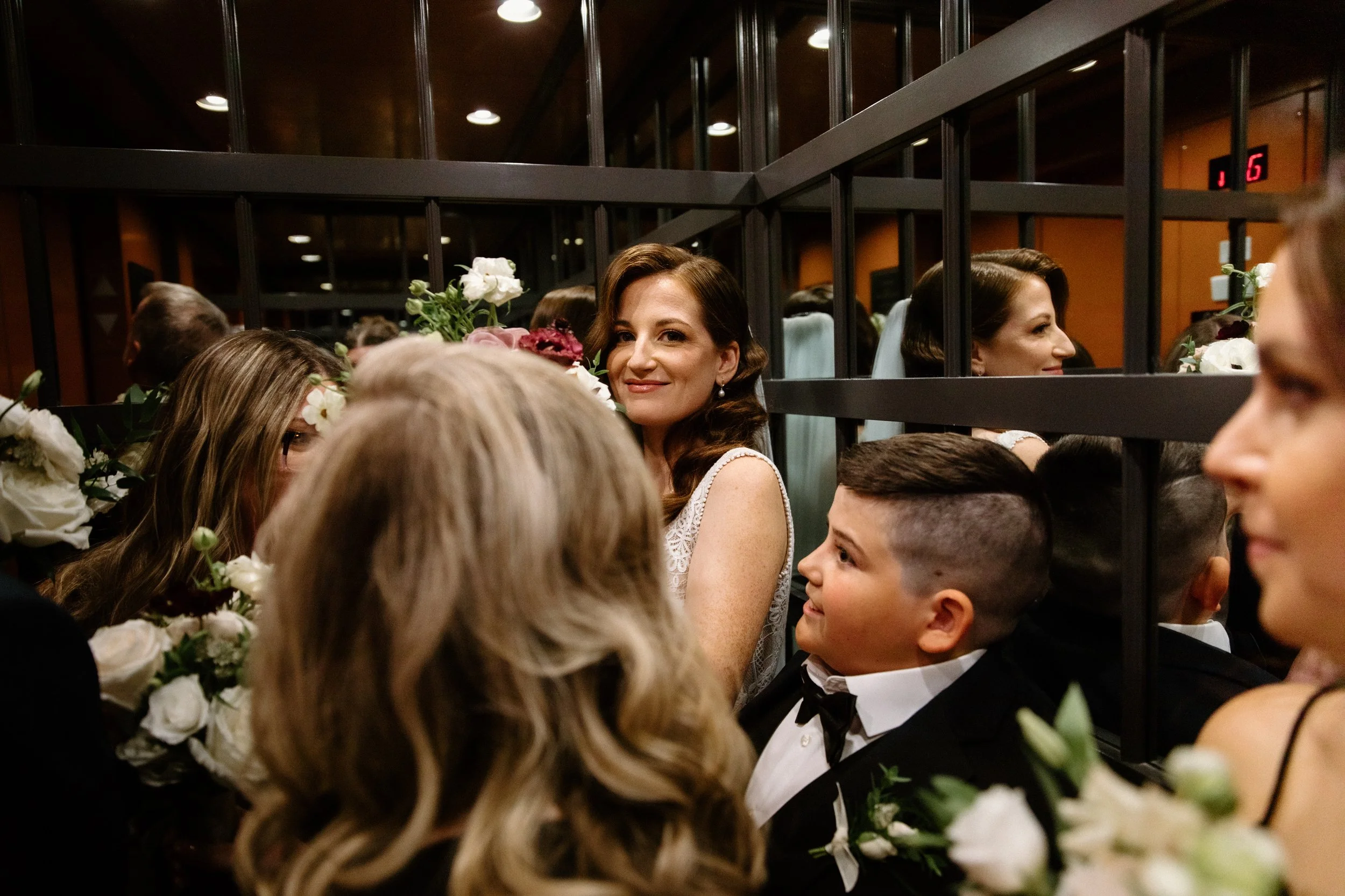 Candid photo of a bride and her wedding party in an elevator on their Toronto wedding day