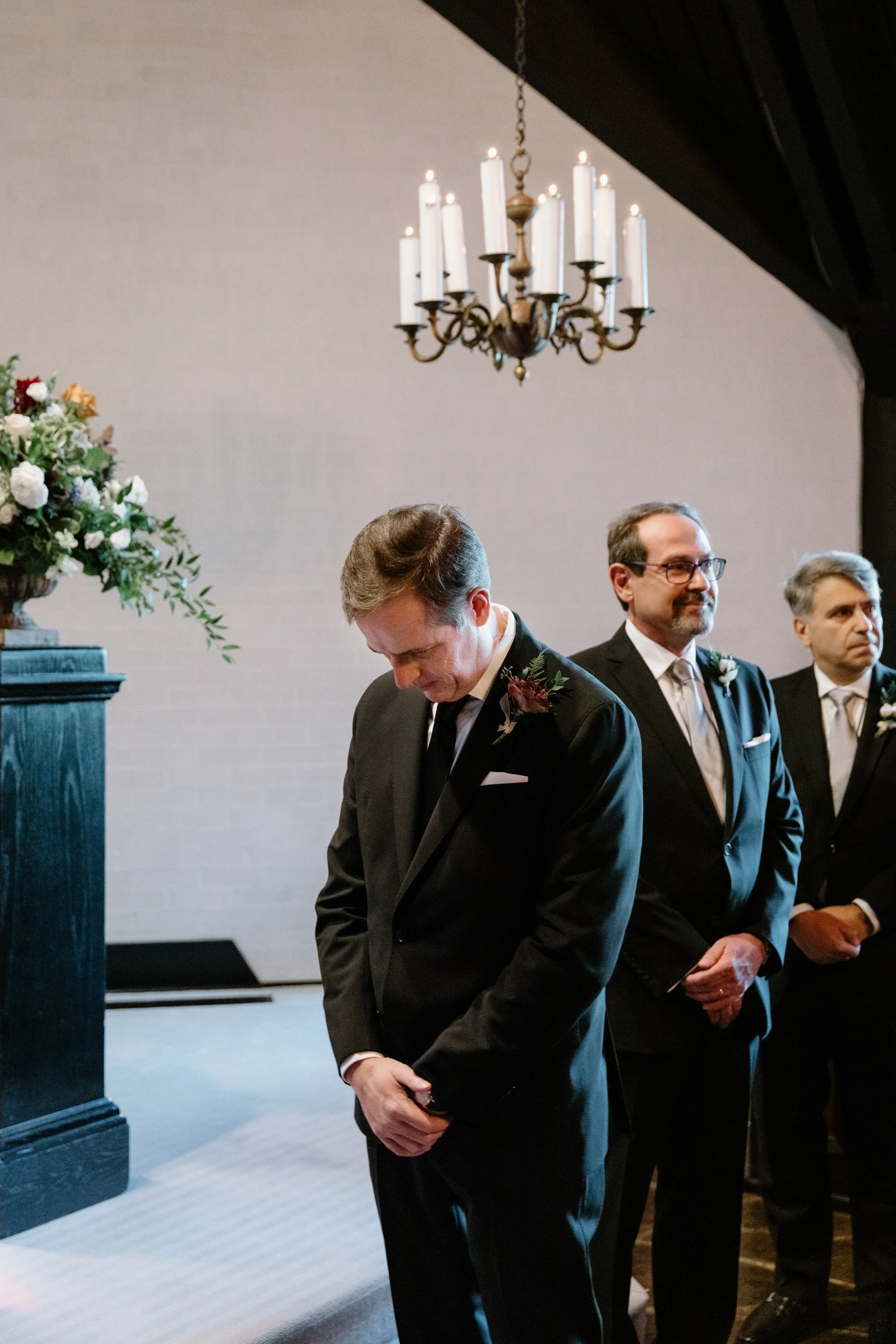Emotional candid of a groom waiting at the altar during his Toronto wedding ceremony, looking down
