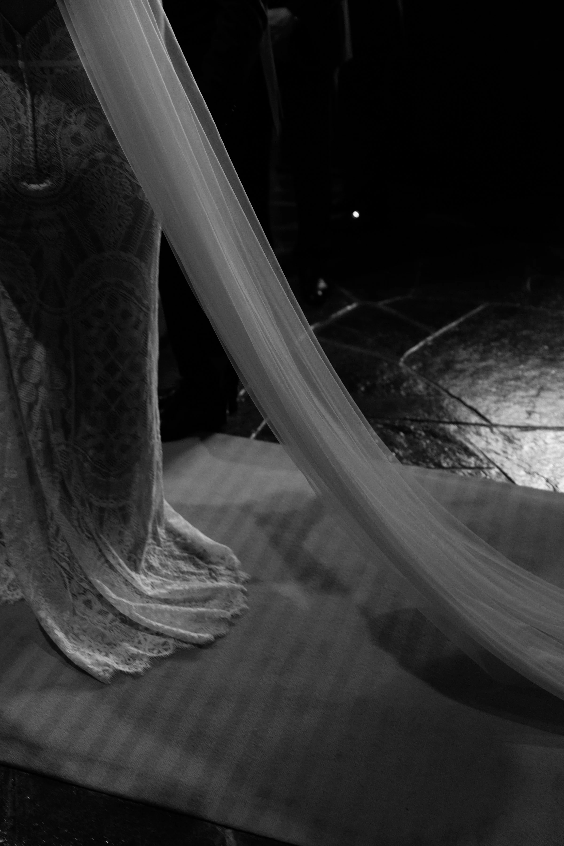Black and white detail photo of a bride's wedding gown and veil on her Toronto wedding day
