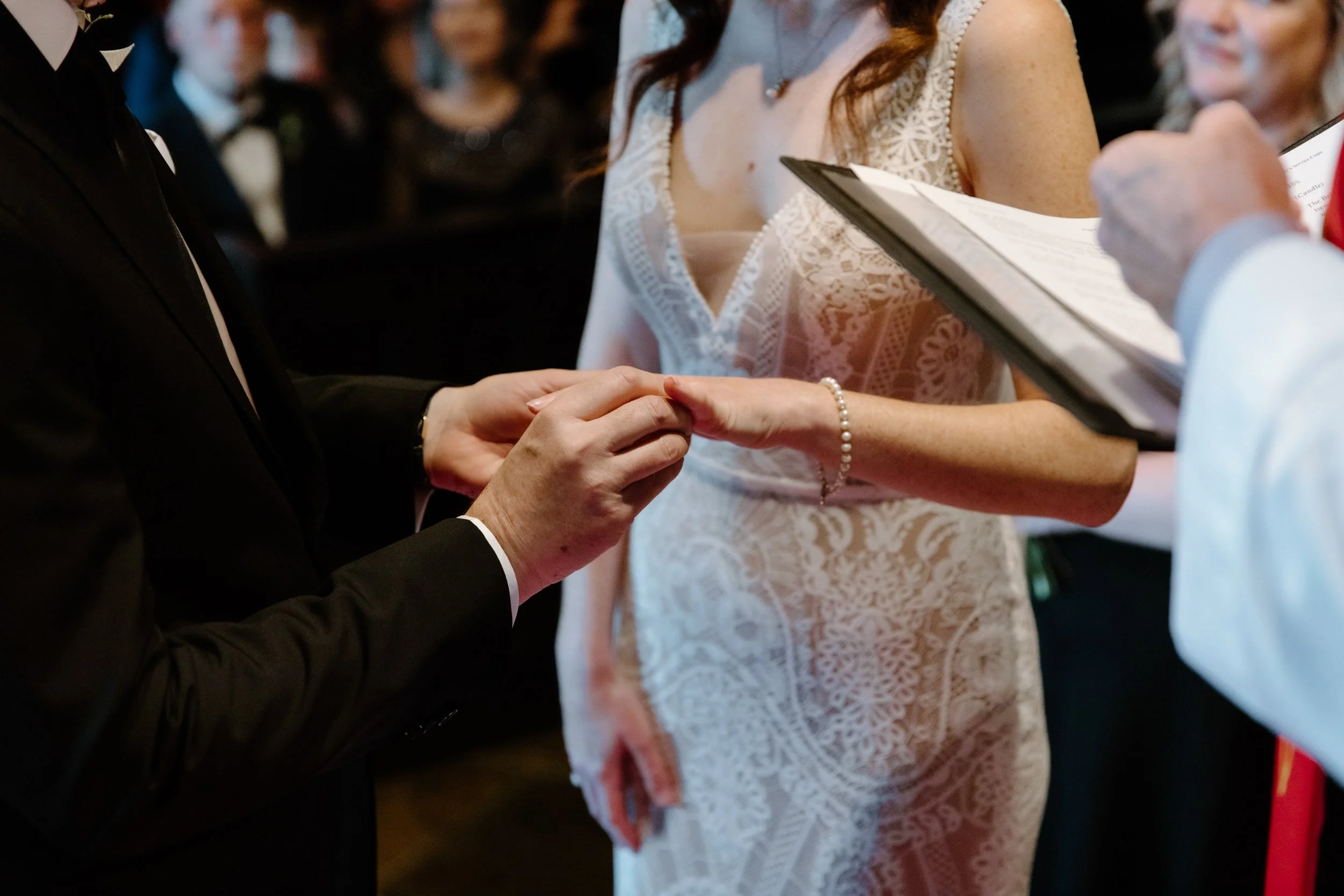 Detail photo of a bride and groom exchanging rings during their Toronto wedding ceremony