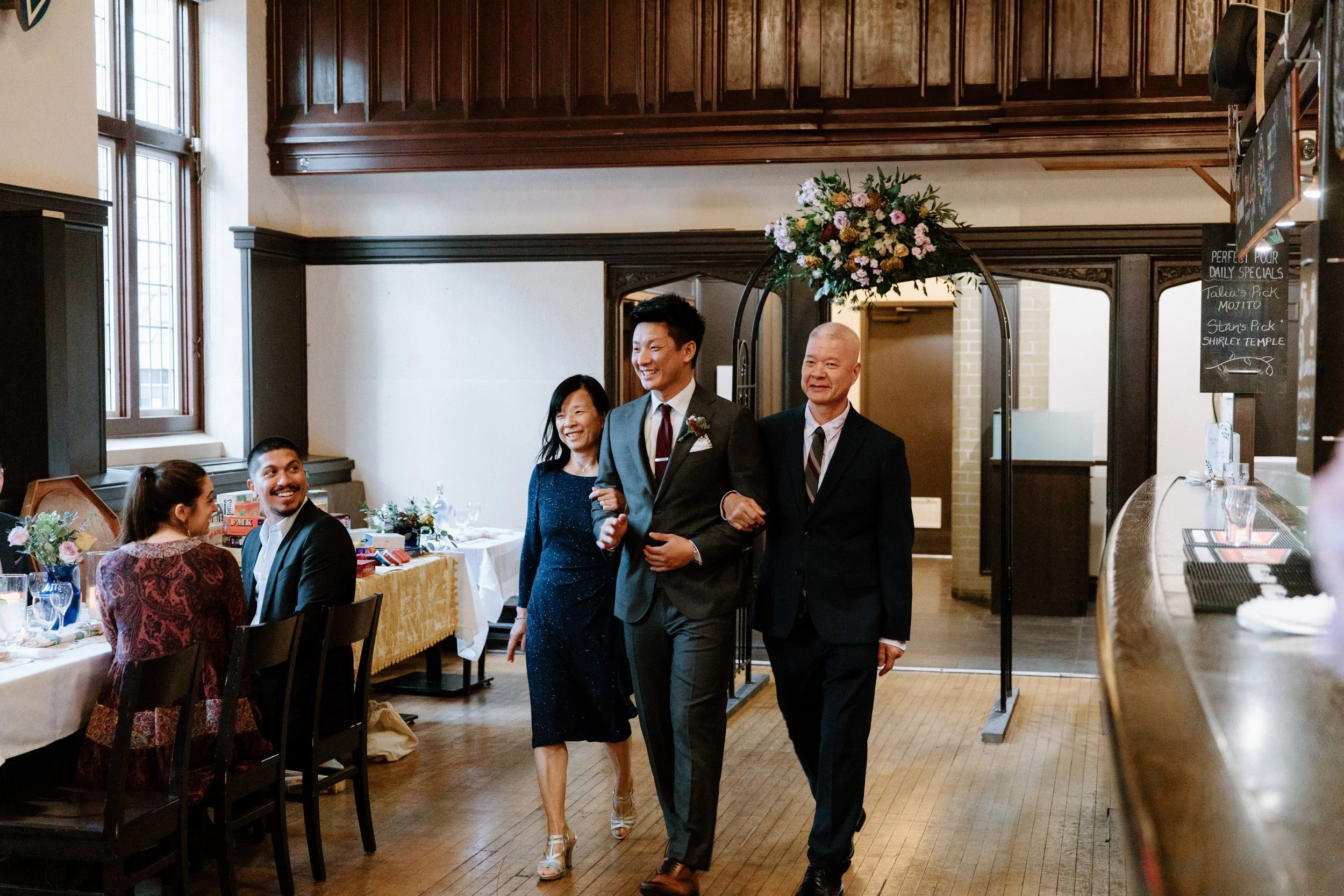 Groom walking to his wedding ceremony with his parents at McMaster University, Hamilton