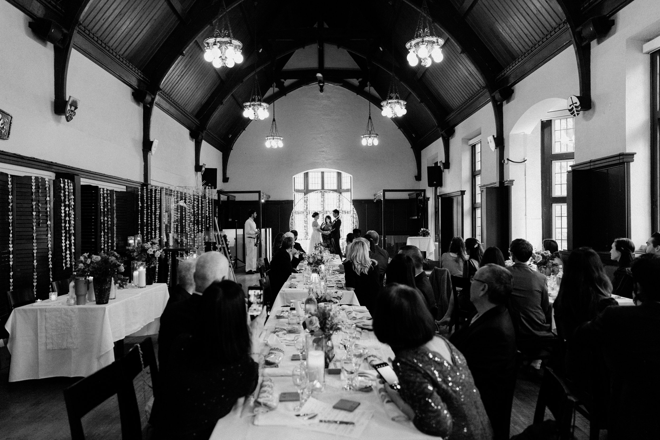 Black and white wide shot of a wedding ceremony at the Phoenix Crafthouse, McMaster University in Hamilton