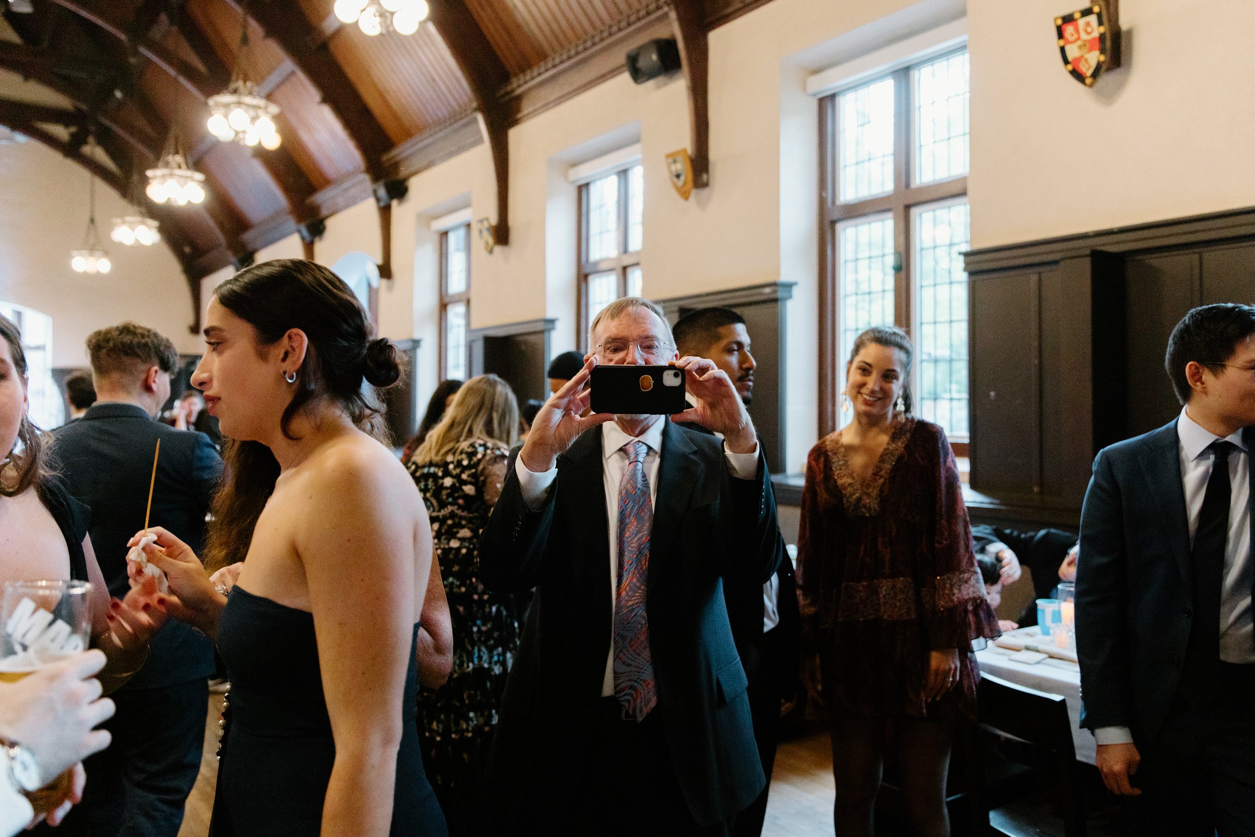 Documentary style candid of wedding guests after the ceremony at a unique university pub wedding in Hamilton