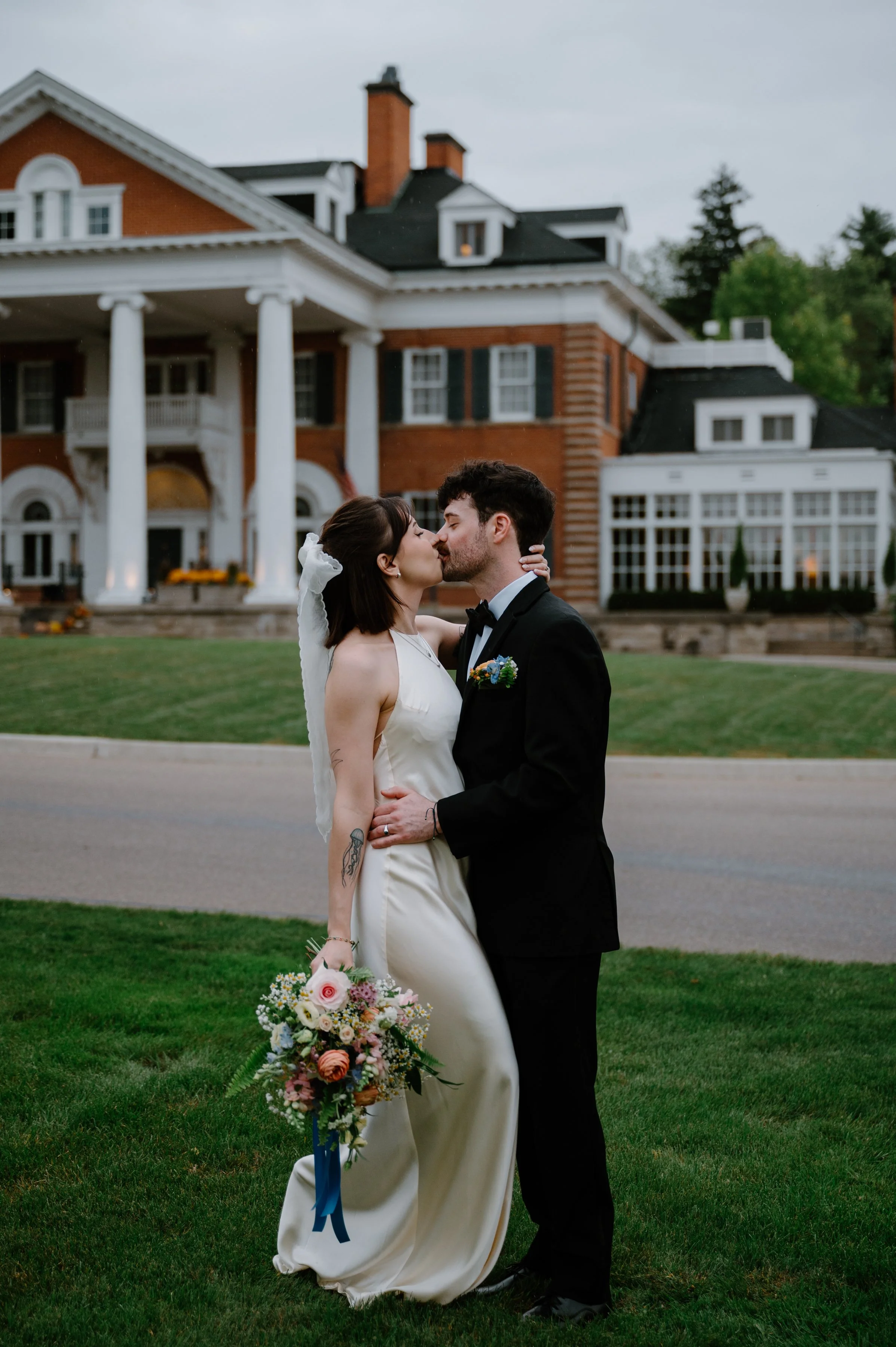 Bride and groom posing in front of Langdon Hall during their intimate wedding reception in Ontario