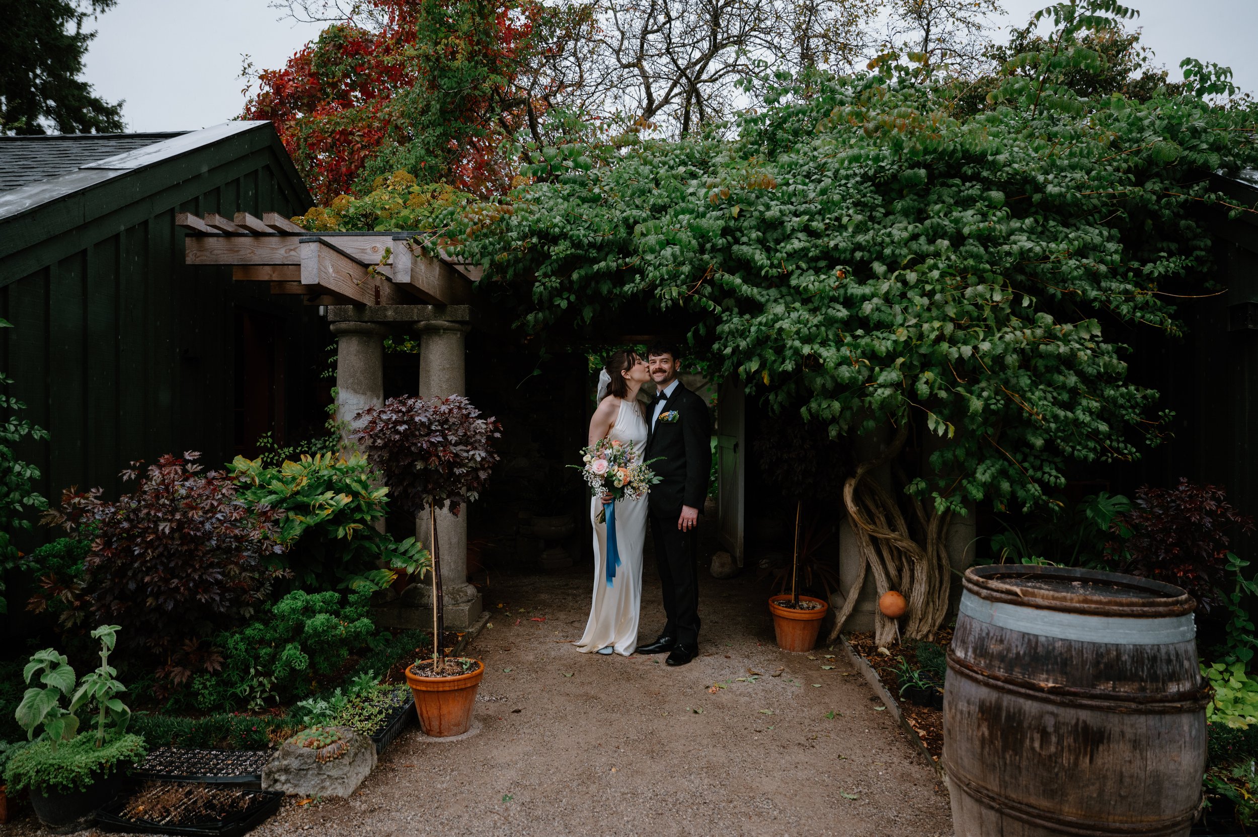 Bride kissing her groom in the gardens at Langdon Hall during their wedding reception in Cambridge, Ontario