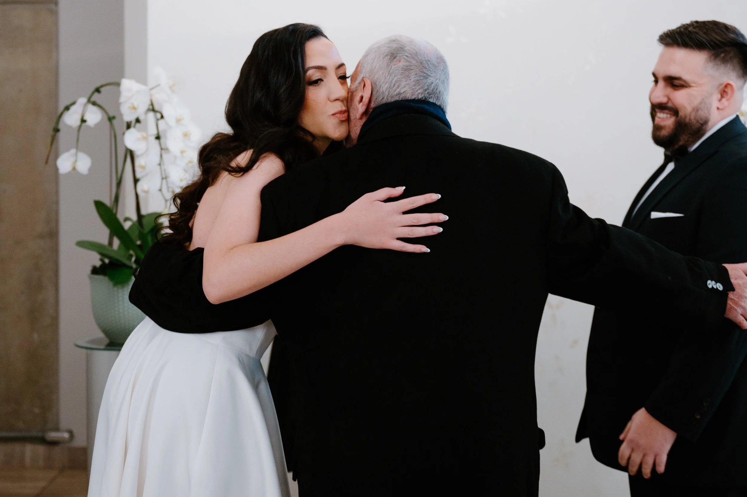 Bride being walked down the aisle by her dad at a winter City Hall wedding