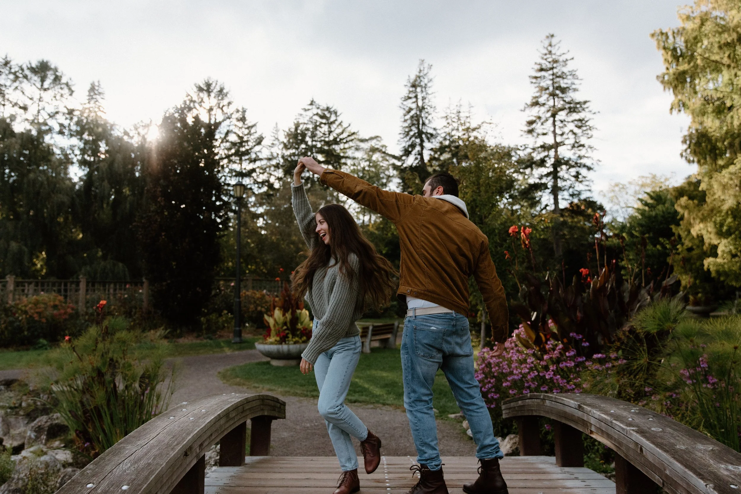 Candid and fun engagement photo of a couple dancing together at a park in Toronto