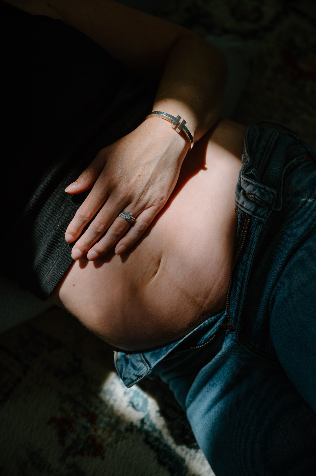 Dramatic editorial inspired portrait of a pregnancy belly during an at-home maternity session in Toronto