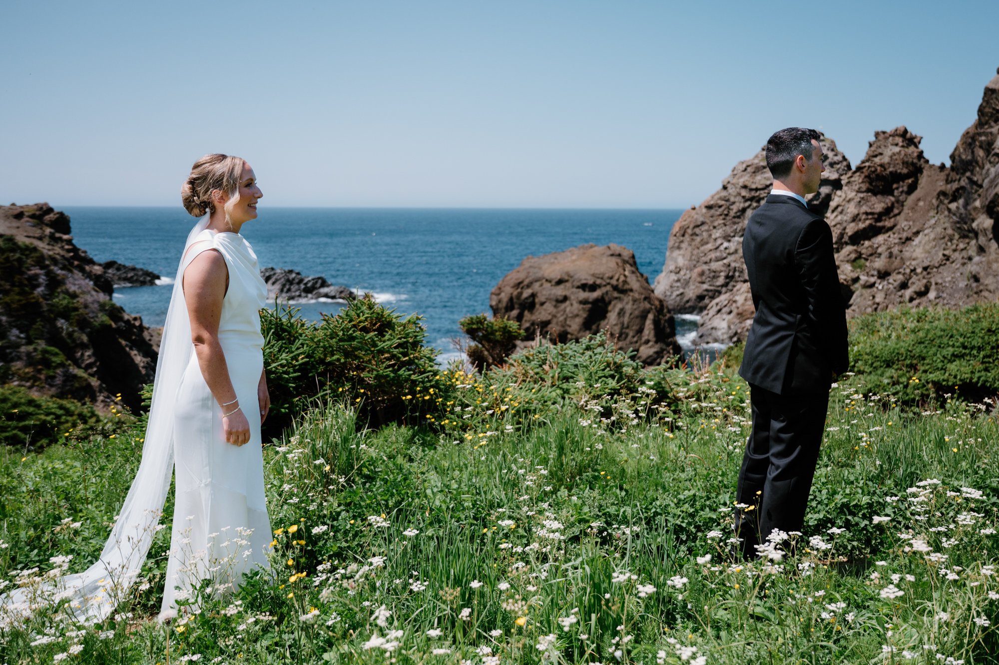 Bride and groom sharing a first look moment at a cliffside destination wedding
