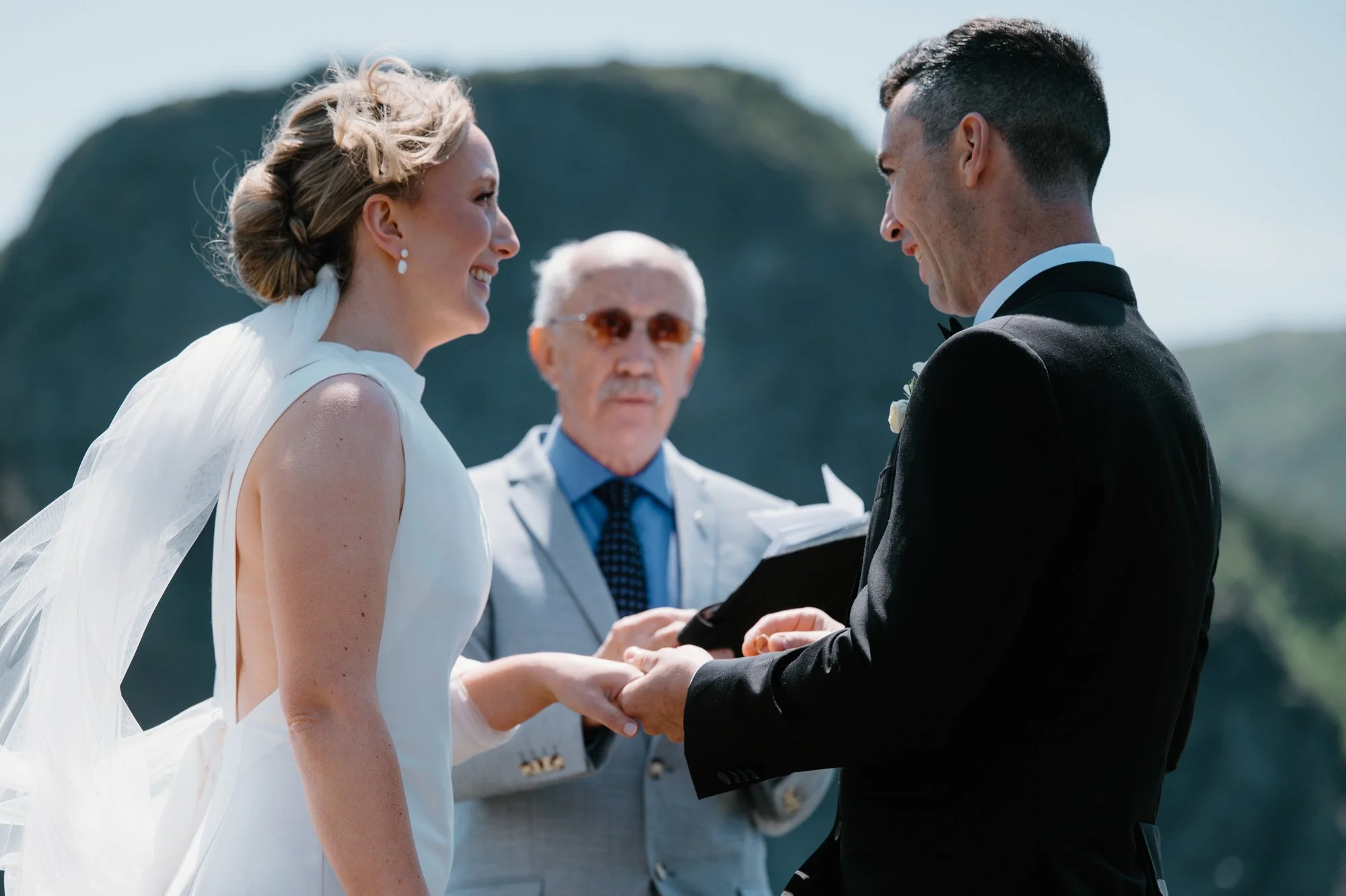 Bride and groom exchanging Bluboho wedding rings during their outdoor ceremony in Newfoundland