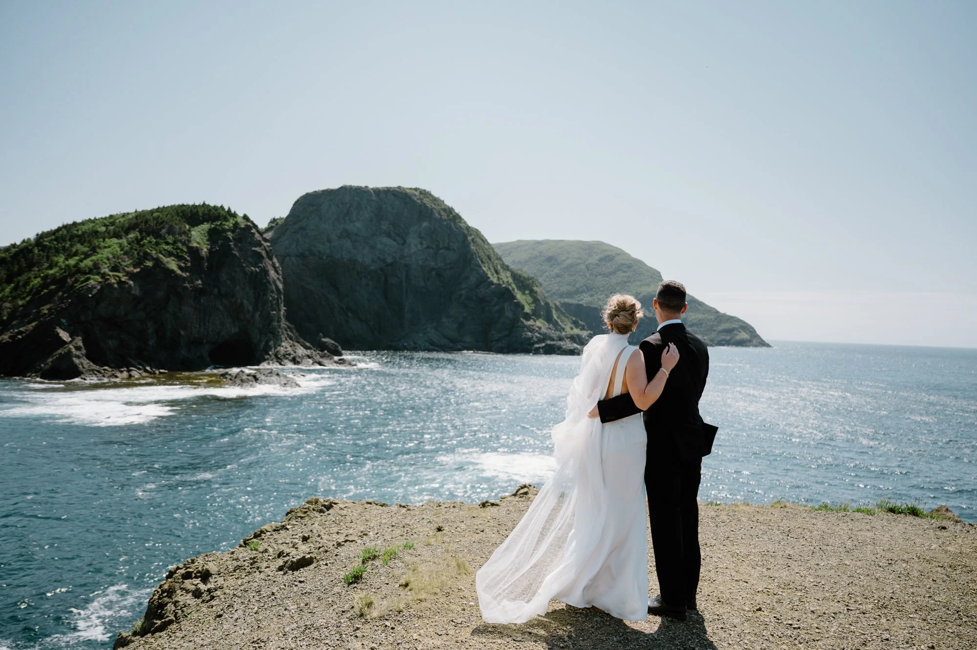 Bride and groom looking out over the Atlantic Ocean at Bottle Cove during their Corner Brook, Newfoundland destination wedding
