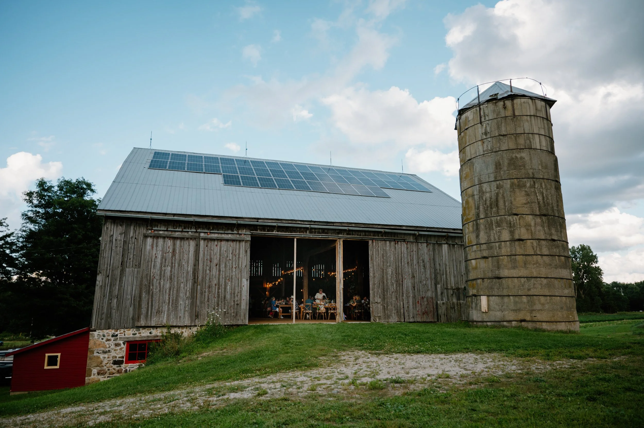 Exterior of a rustic barn lit up during a farm wedding reception near Orangeville, Ontario