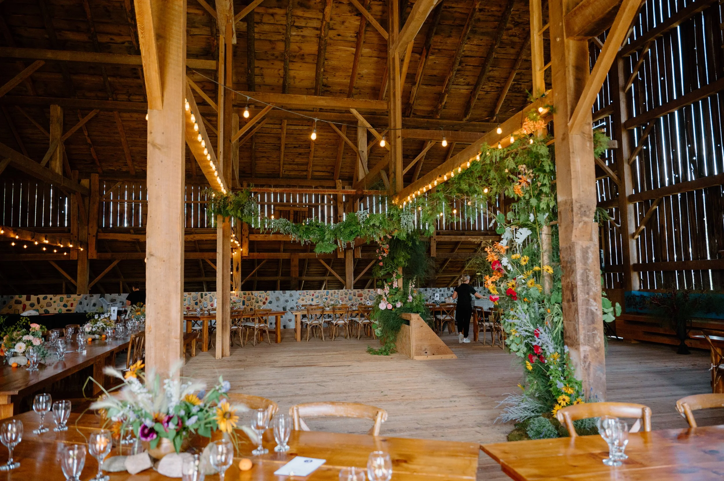 Wide room photo of a beautifully decorated rustic barn wedding reception near Orangeville, Ontario