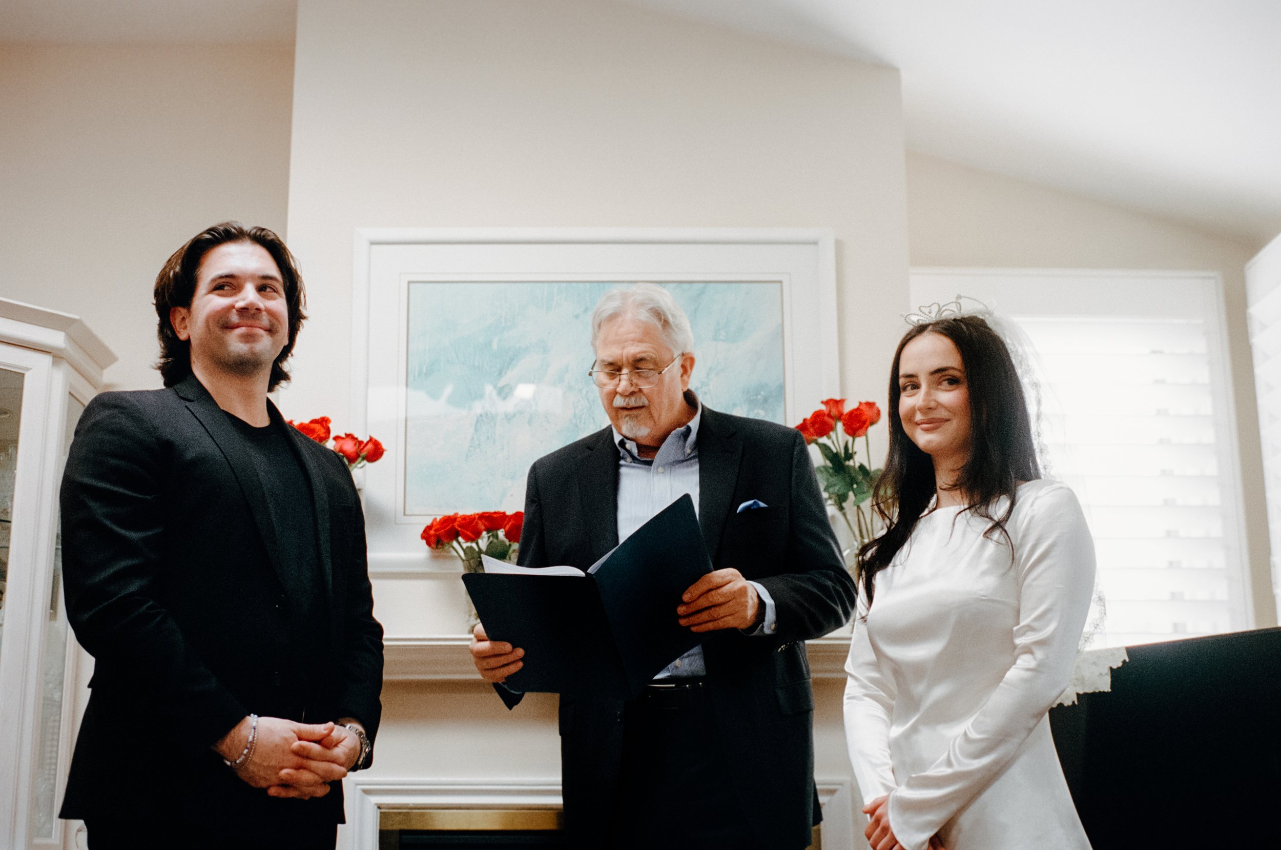 Candid film photograph taken during an intimate civil ceremony in a living room in Toronto