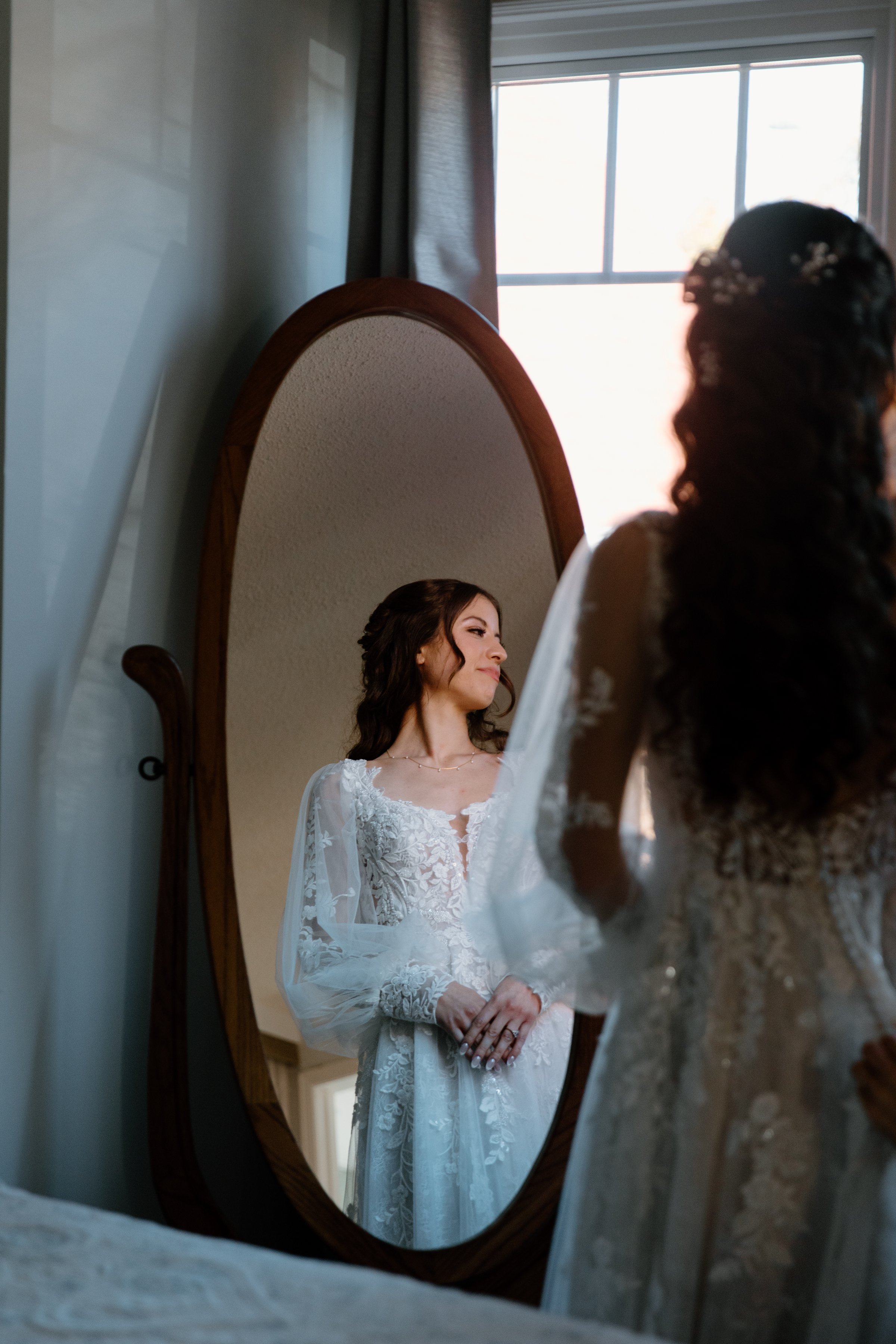 Portrait of a bride through the reflection of a mirror shot in an editorial wedding photography style.