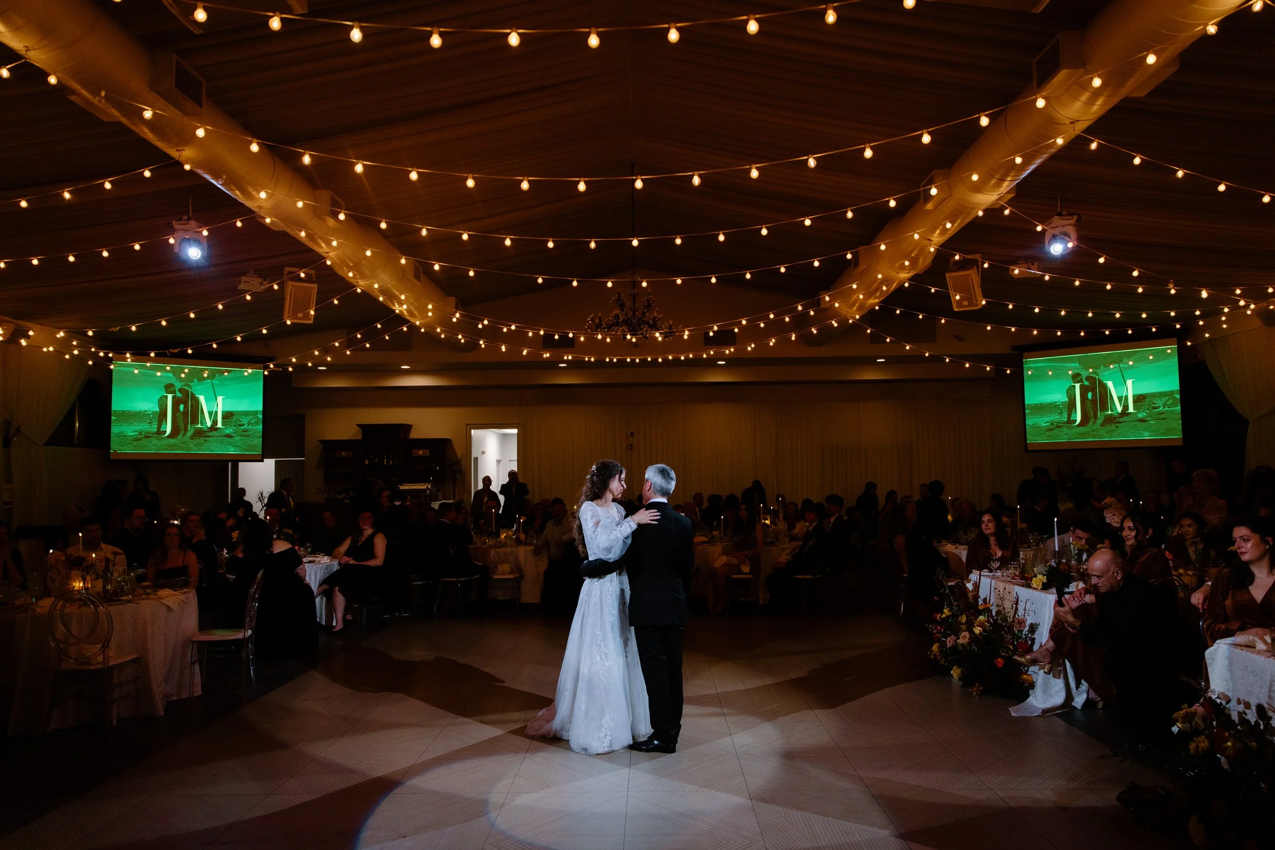 Wide room photo of a father-daughter dance at a Caledon wedding reception