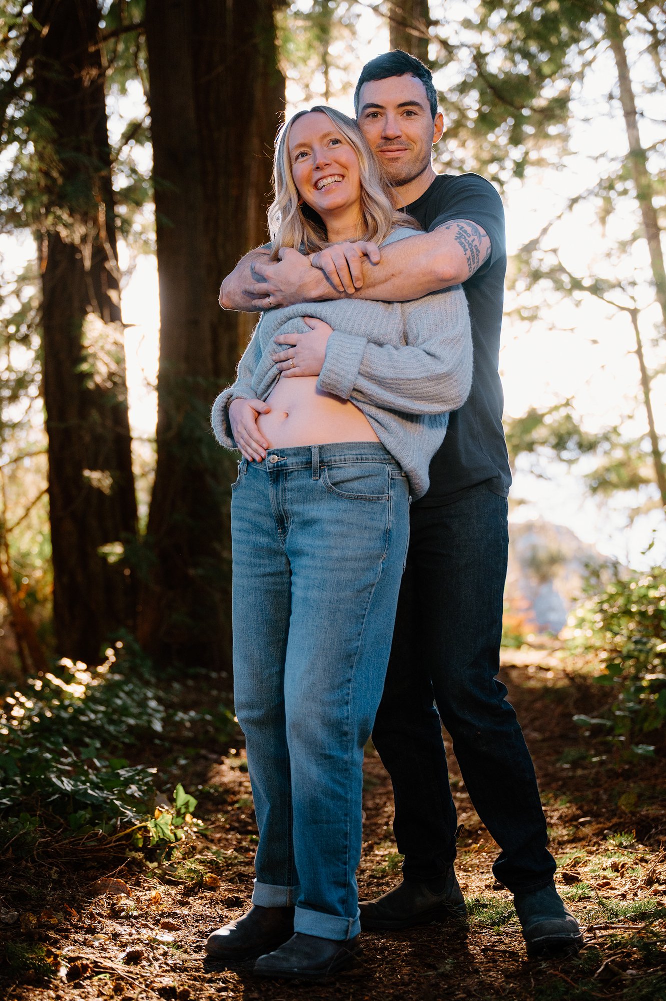 Joyful candid maternity photo of a couple hugging and smiling together during their maternity session in Victoria, BC