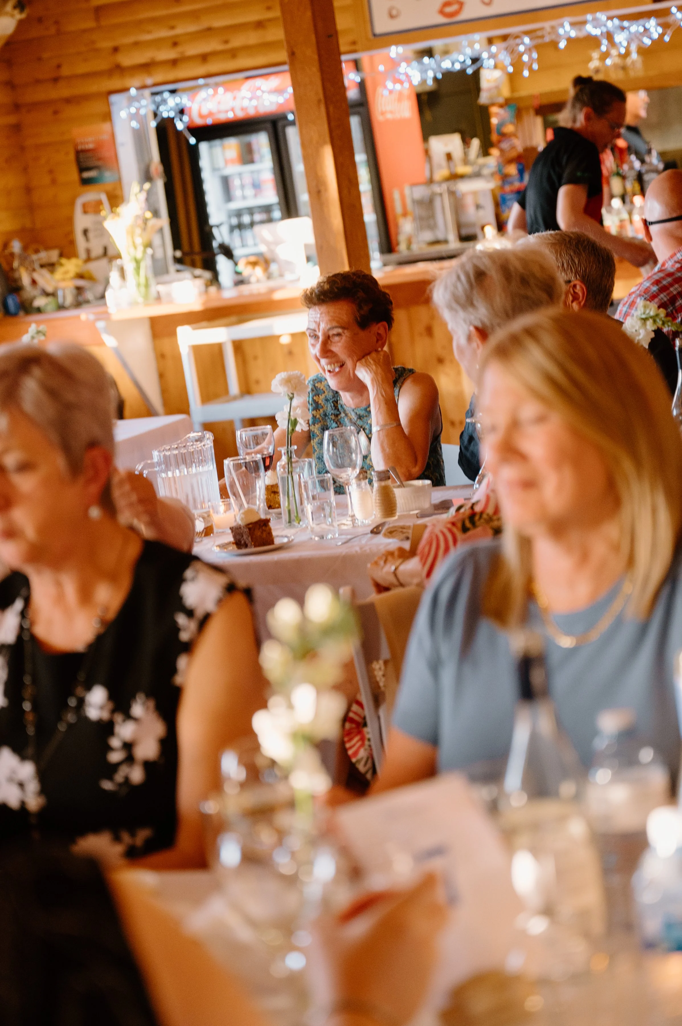 Documentary style photo of guests laughing and enjoying themselves during a destination wedding reception in Newfoundland