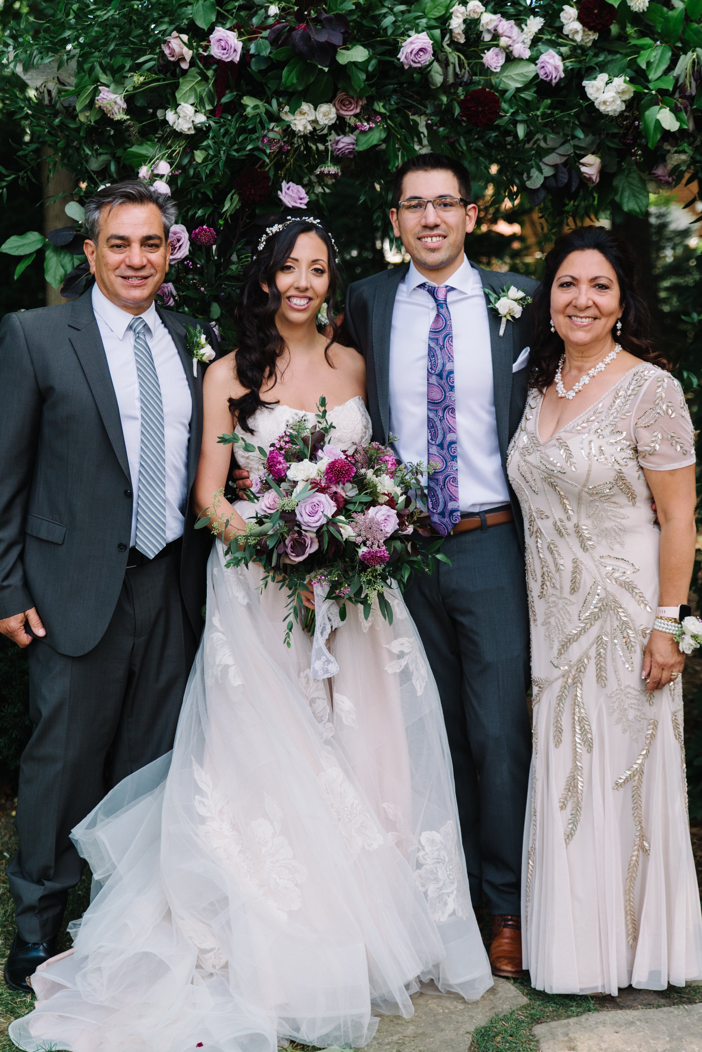 Family formal portrait under a stunning floral arch by The Paisley Rose at a backyard micro-wedding in Toronto