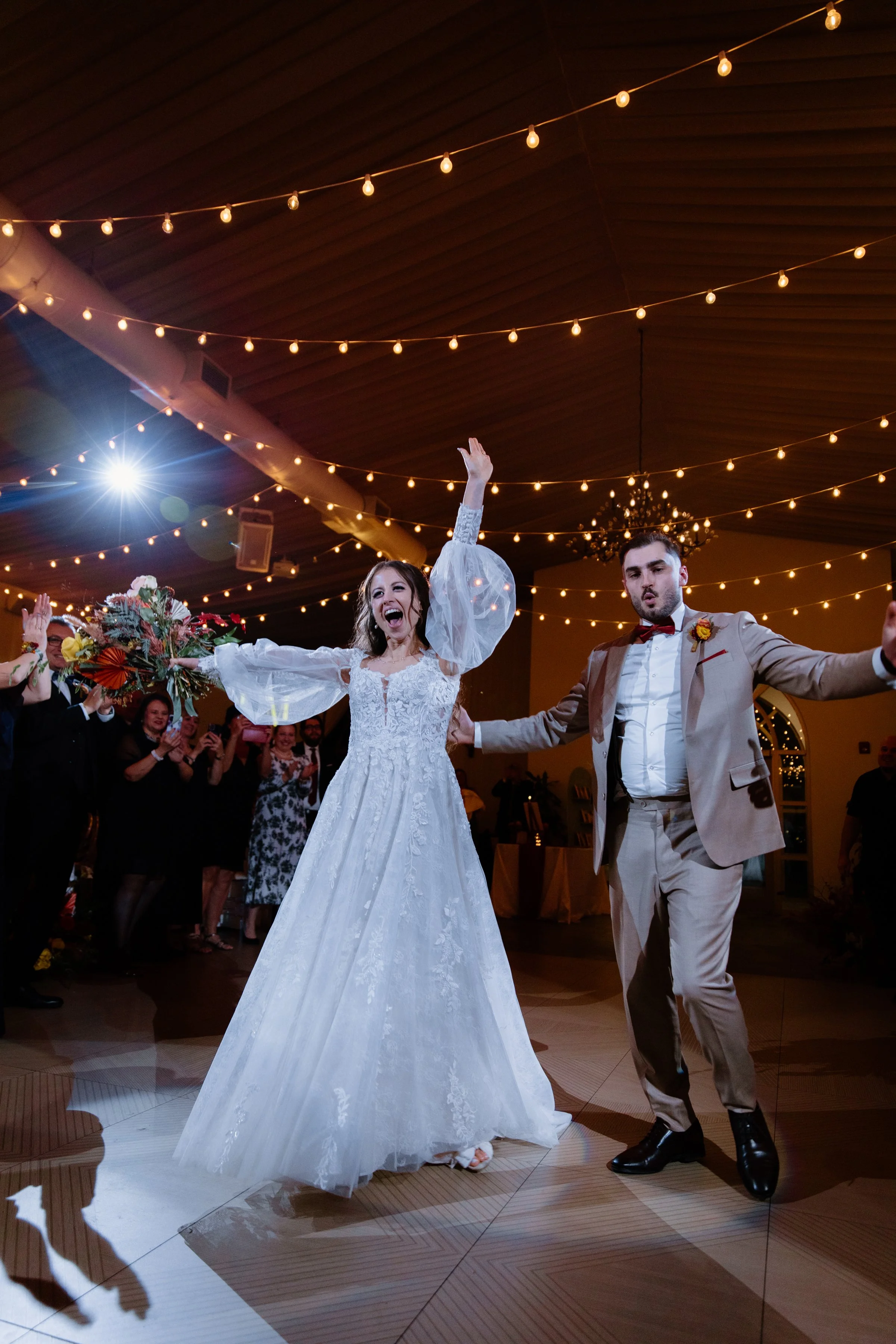 Candid photo of a bride and groom entering their wedding reception, excited and ecstatic, at the Royal Ambassador in Caledon