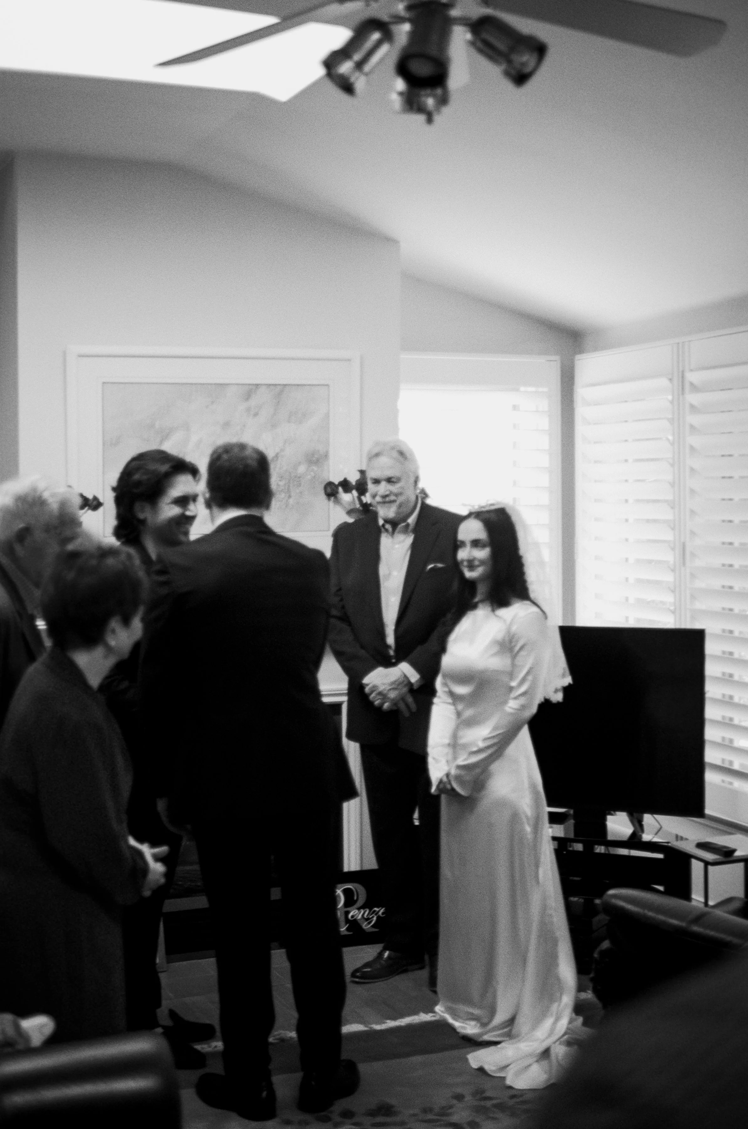 Black and white film photograph of a bride and groom at the front of their living room during an intimate civil ceremony in Vancouver