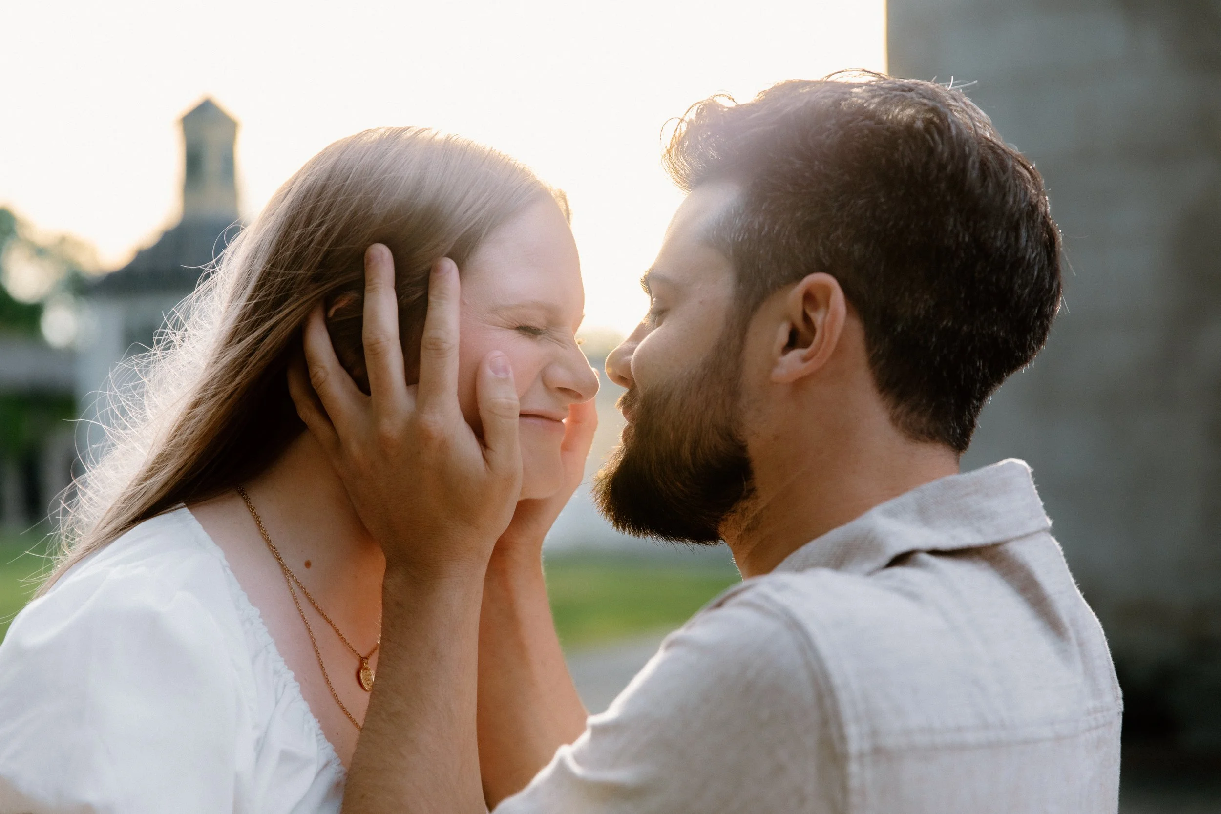 Romantic close up portrait of a couple face to face and smiling with golden hour sun glowing behind them at Dundurn Castle