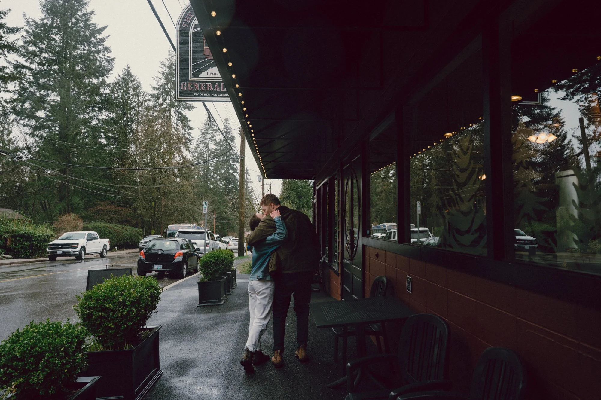 Editorial photo of a couple walking and kissing in front of the End of the Line General Store in Lynn Valley, North Vancouver