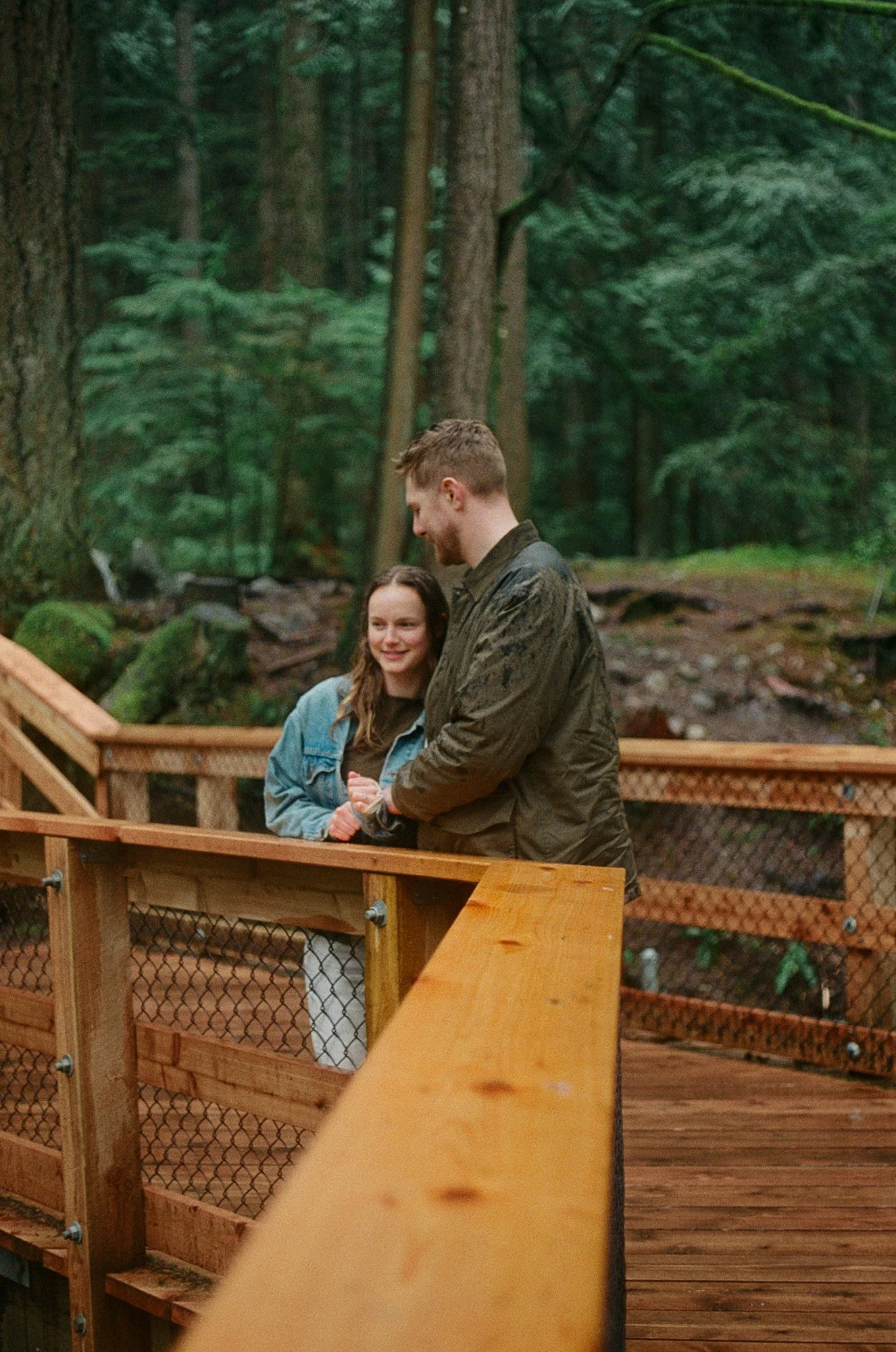 Candid film photograph of a couple at Lynn Valley canyon in North Vancouver during a rainy engagement session