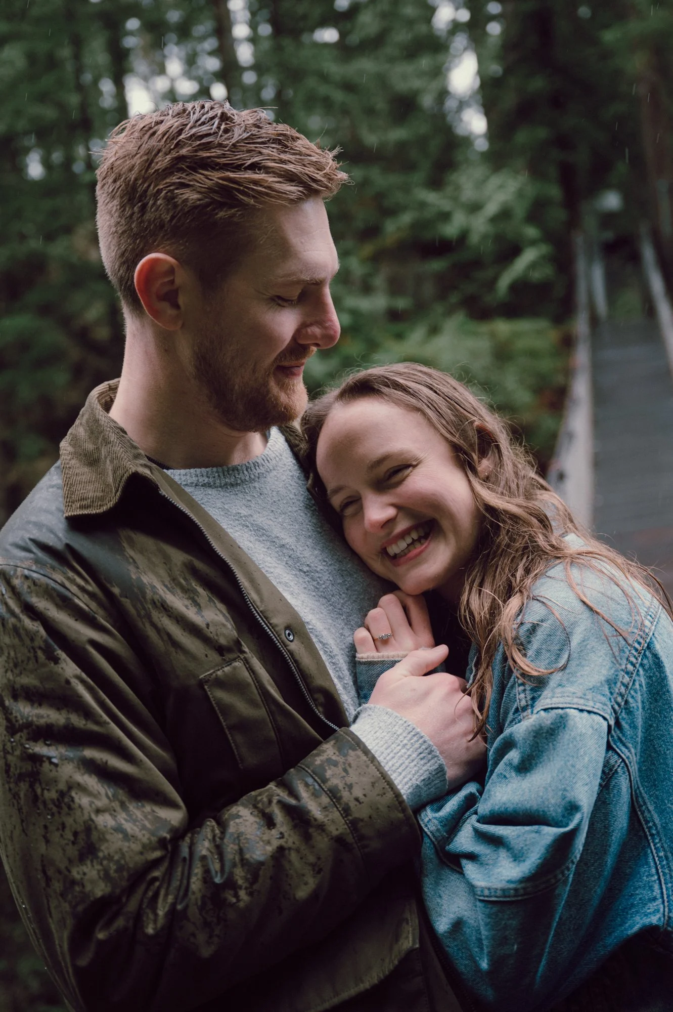 Intimate portrait of a couple embracing on the Lynn Valley suspension bridge in North Vancouver