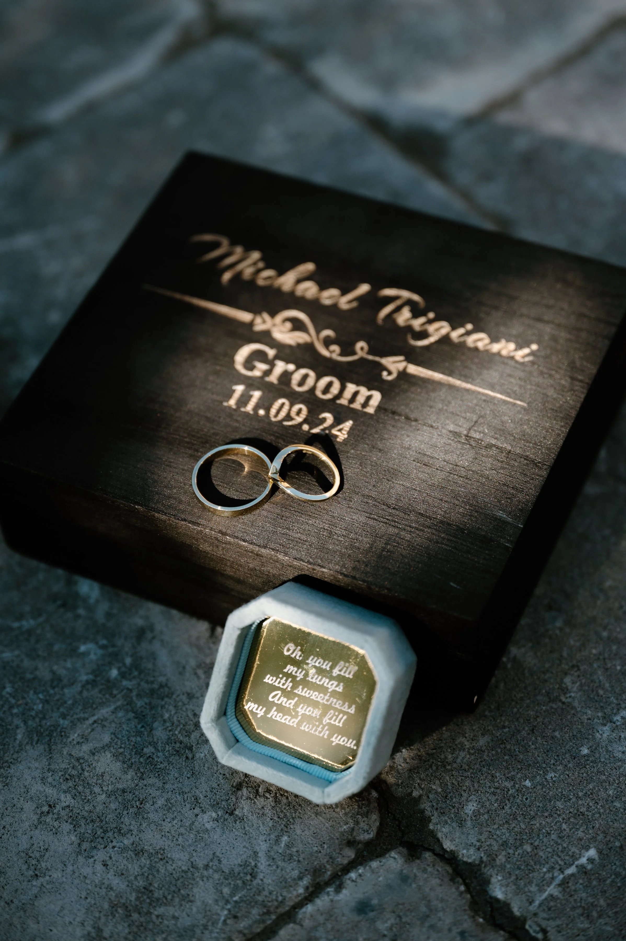 Detail photo of a groom's rings and custom engraved ring box and groom box on his Toronto wedding day