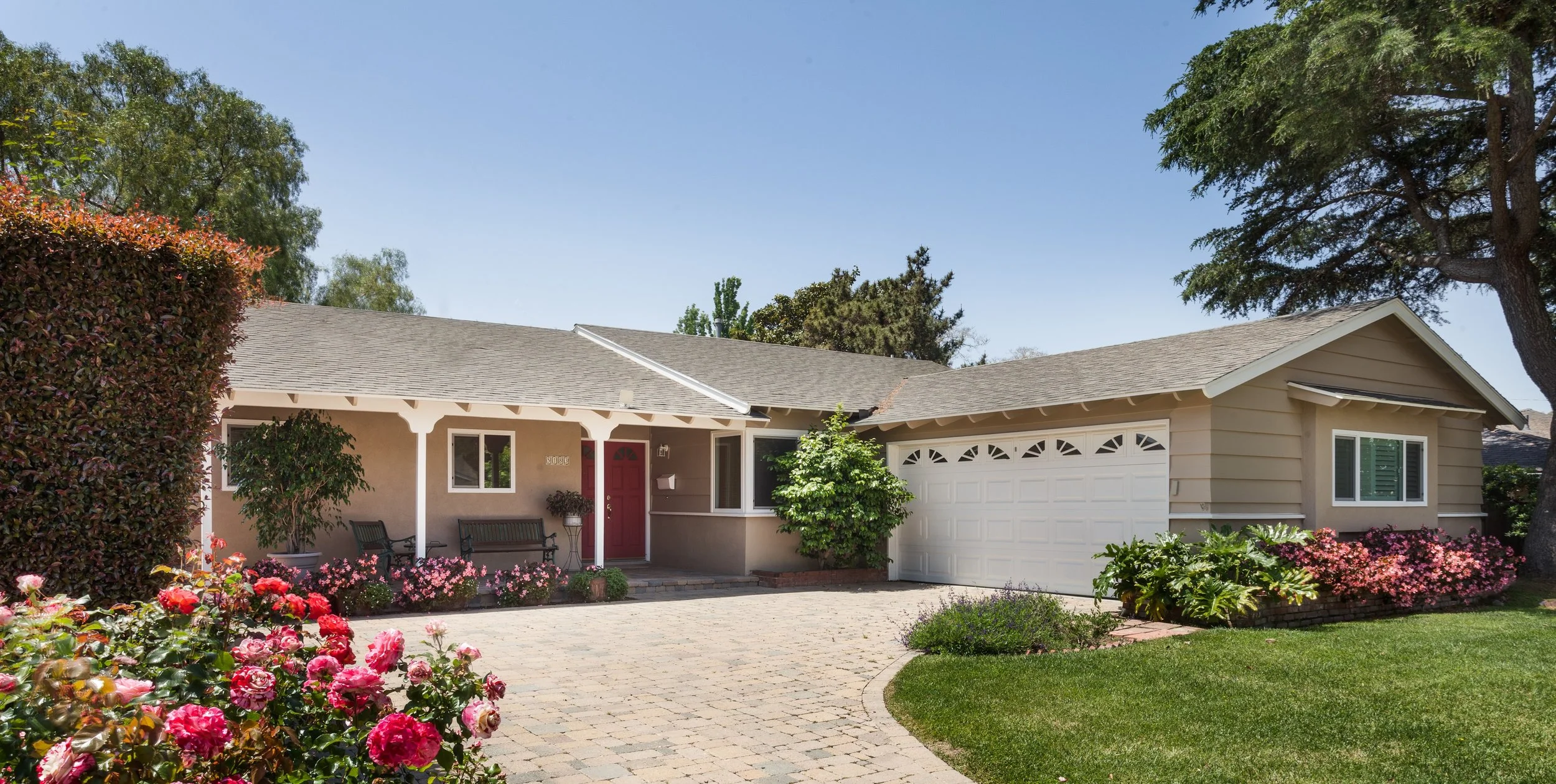 Goleta residence, exterior taupe stucco, white trim, red front door, paving stones