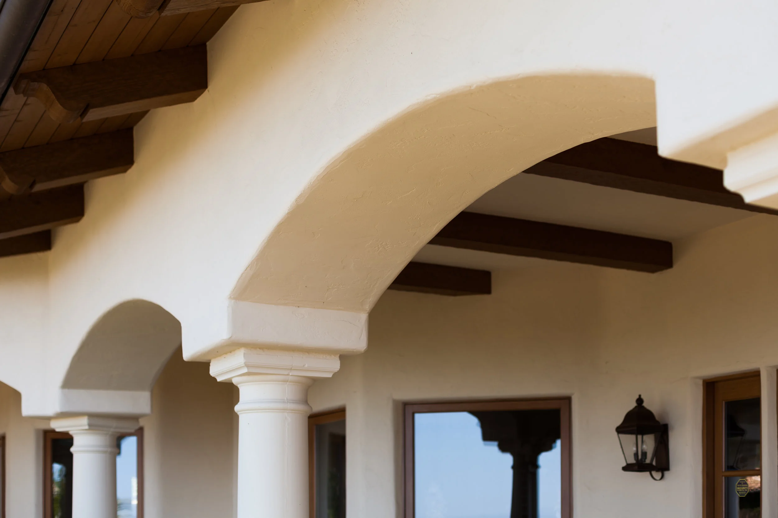 Montecito residence, exterior painting, mission smooth stucco, arches and columns, dark brown stained beams and eaves