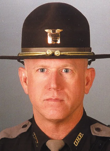 Trooper Rocky Eales September 24, 1999 Eales joined the patrol in 1979. Trooper Eales, was shot and killed while assisting the DA’s drug task force in Sequoyah County while attempting to serve felony warrants on September 24. Members of the OHP Tactical Team arrived at a residence near Sallisaw to serve a warrant. Upon approaching the residence Troopers John M. “Buddy” Hamilton and David W. “Rocky” Eales were fired upon. Trooper Hamilton received non- fatal wounds to both shoulders and left eye. Trooper Eales received a fatal wound and expired at the scene. Kenneth Eugene Barrett, 38, is being charged with murder and shooting with intent to kill. 