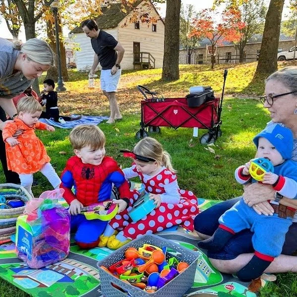 Children enjoying a lively, interactive family music class in the park, engaging in songs, movement, and playful activities suitable for all ages