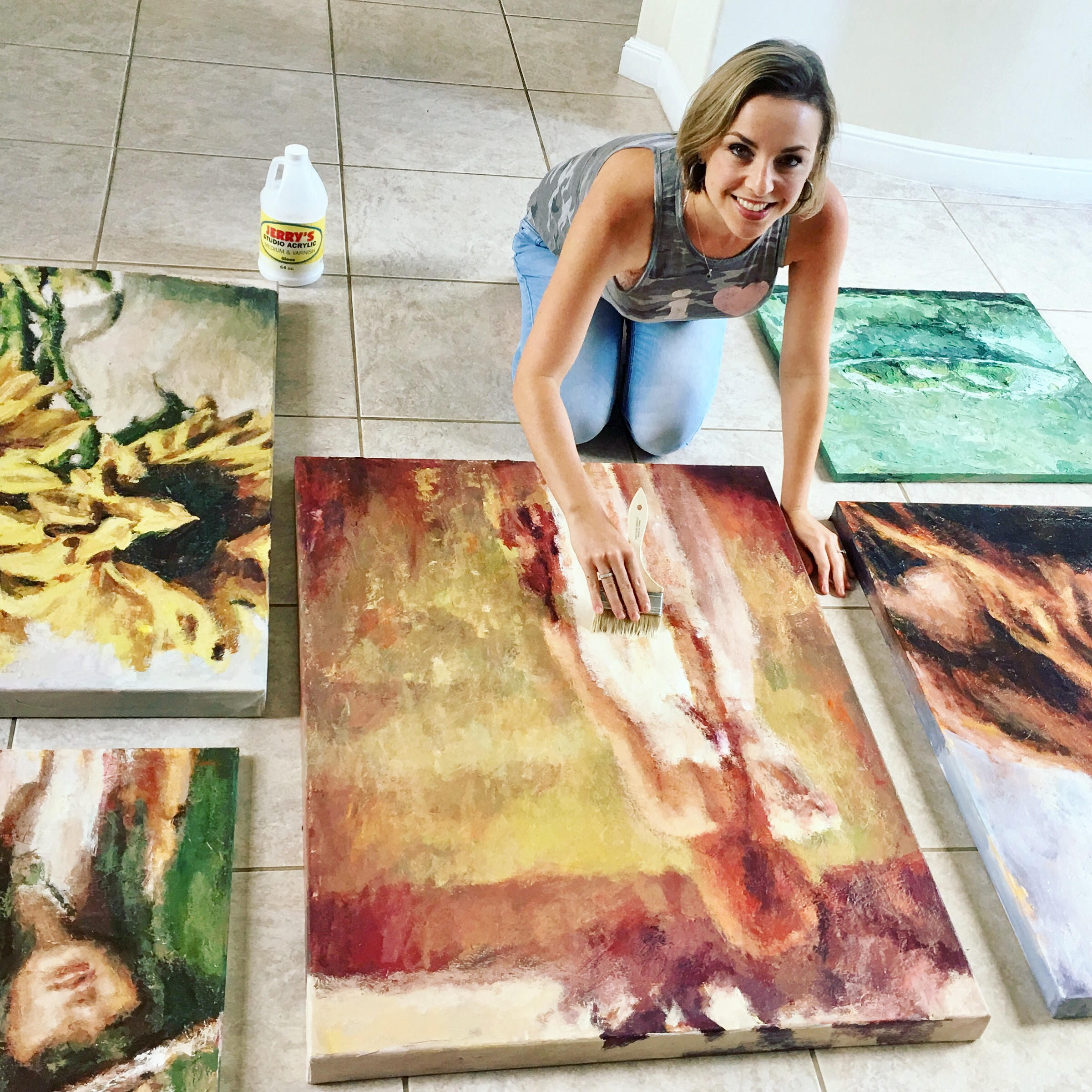 Artist Nava Lundy varnishing her paintings
