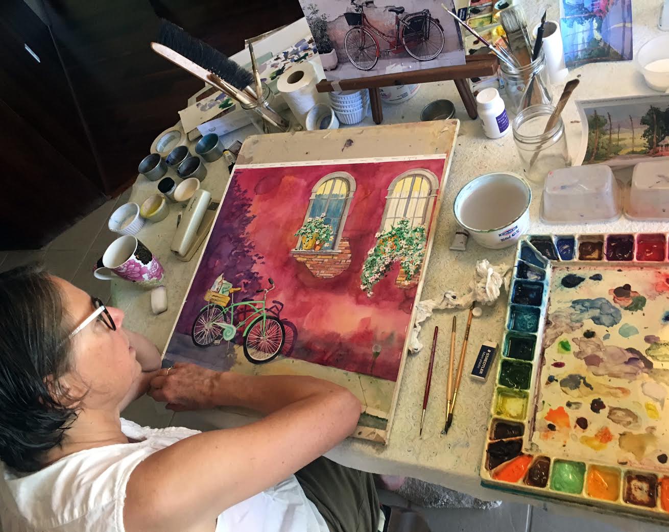Nancy Muren in her studio working on watercolor painting, Shopping in Style