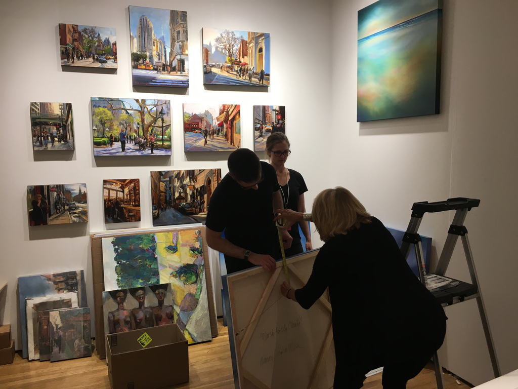Measuring artwork by Nancy Hughes Miller for proper installation. Artwork by Jonelle Summerfield , James Hartman and Allen Wittert also photographed.