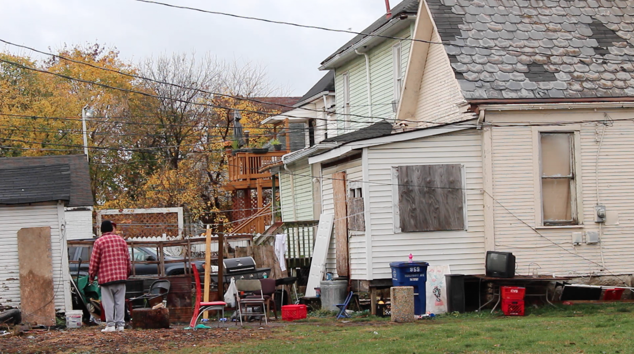   Two men stand in the backyard of a home in the East Franklinton neighborhood of Columbus, Ohio. November, 2015.  