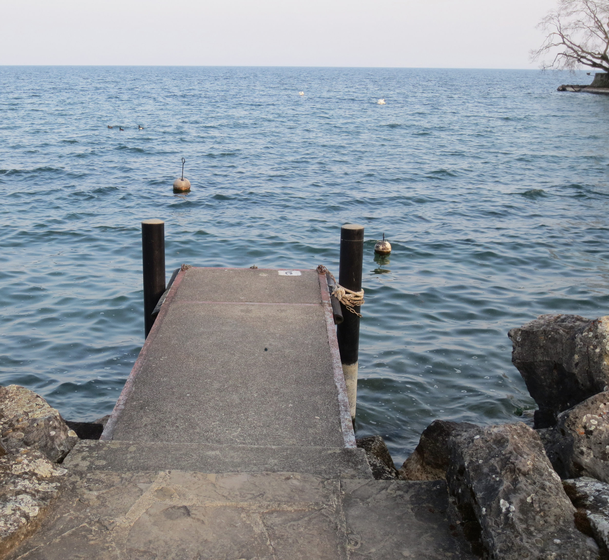   A dock stretches out onto the shore of Lake Geneva in the village of Rolle, Switzerland. June, 2012.  